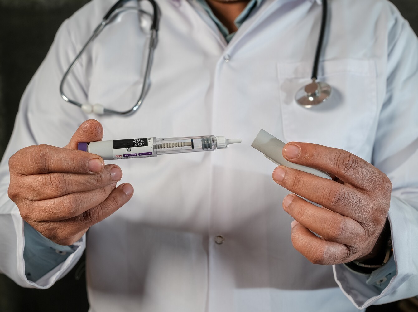 doctor holding out one of the popular weight loss injections to show it to a patient