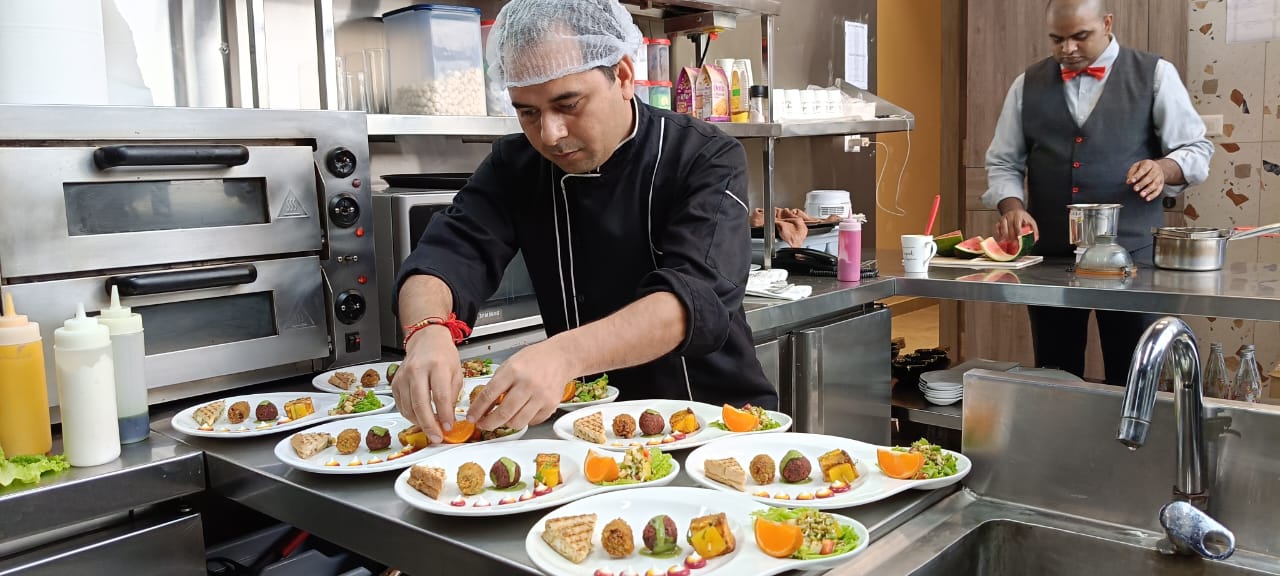 a man in a red hat cutting broccoli on a cutting board