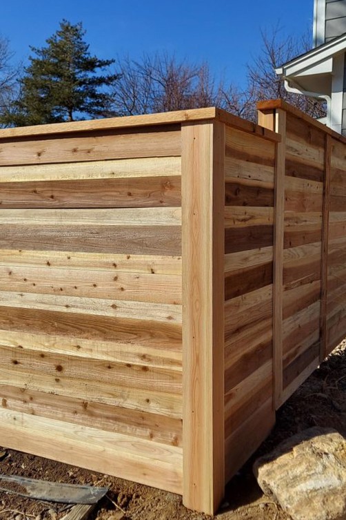 Flat-lay of curated material samples including stone tiles, textured fabrics, ceramics, and botanicals arranged on a neutral surface.