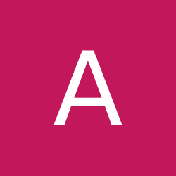 A smiling man with short brown hair in a dark blazer and white shirt against a light gray background. His expression conveys warmth and friendliness.