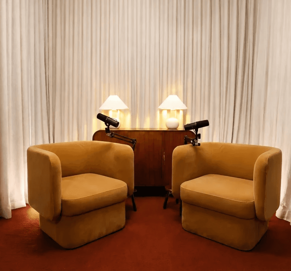 The Collingwood studio's COVE set — two mustard armchairs with microphones and lamps against cream curtains
