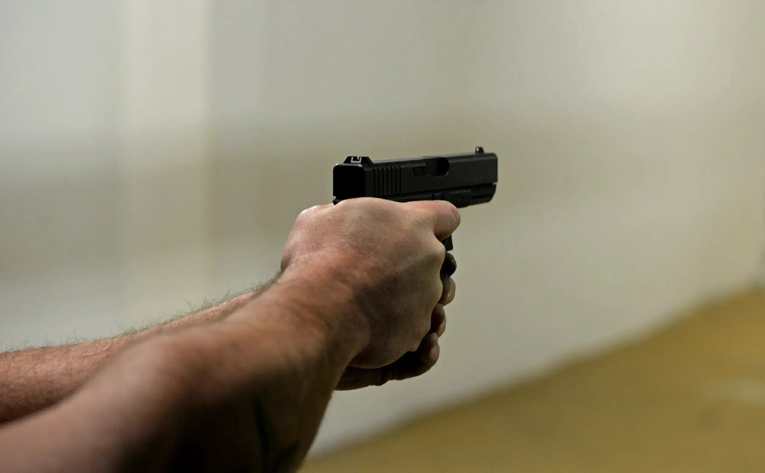 Armed security officer practicing handgun training at indoor shooting range