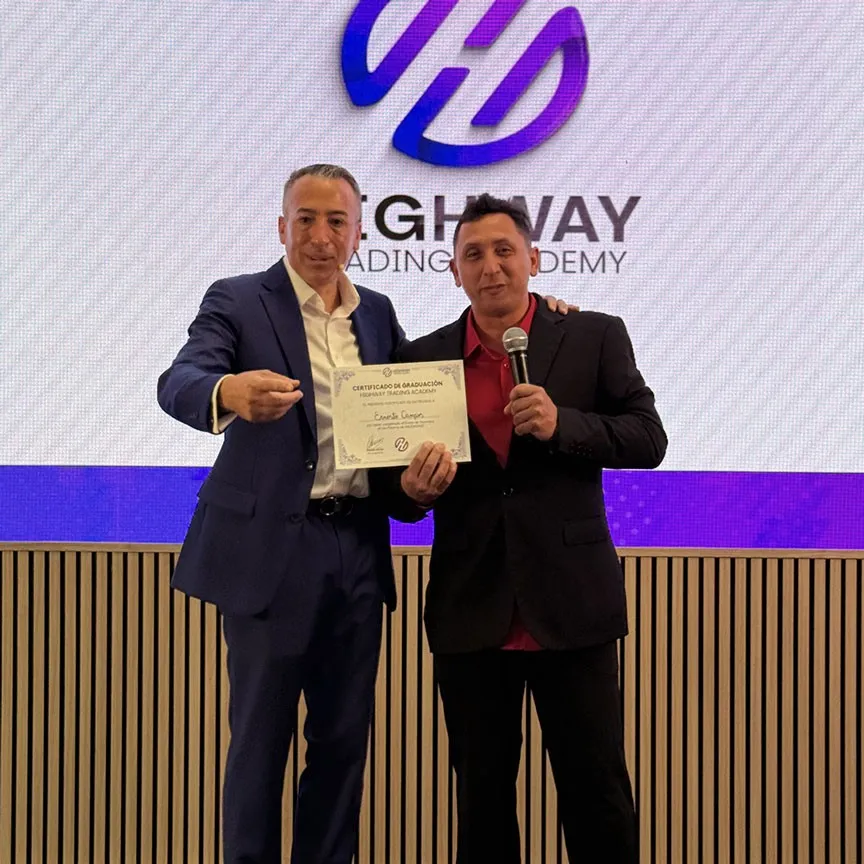 Hombre recibe certificado de la mano de Adrián en la academia.