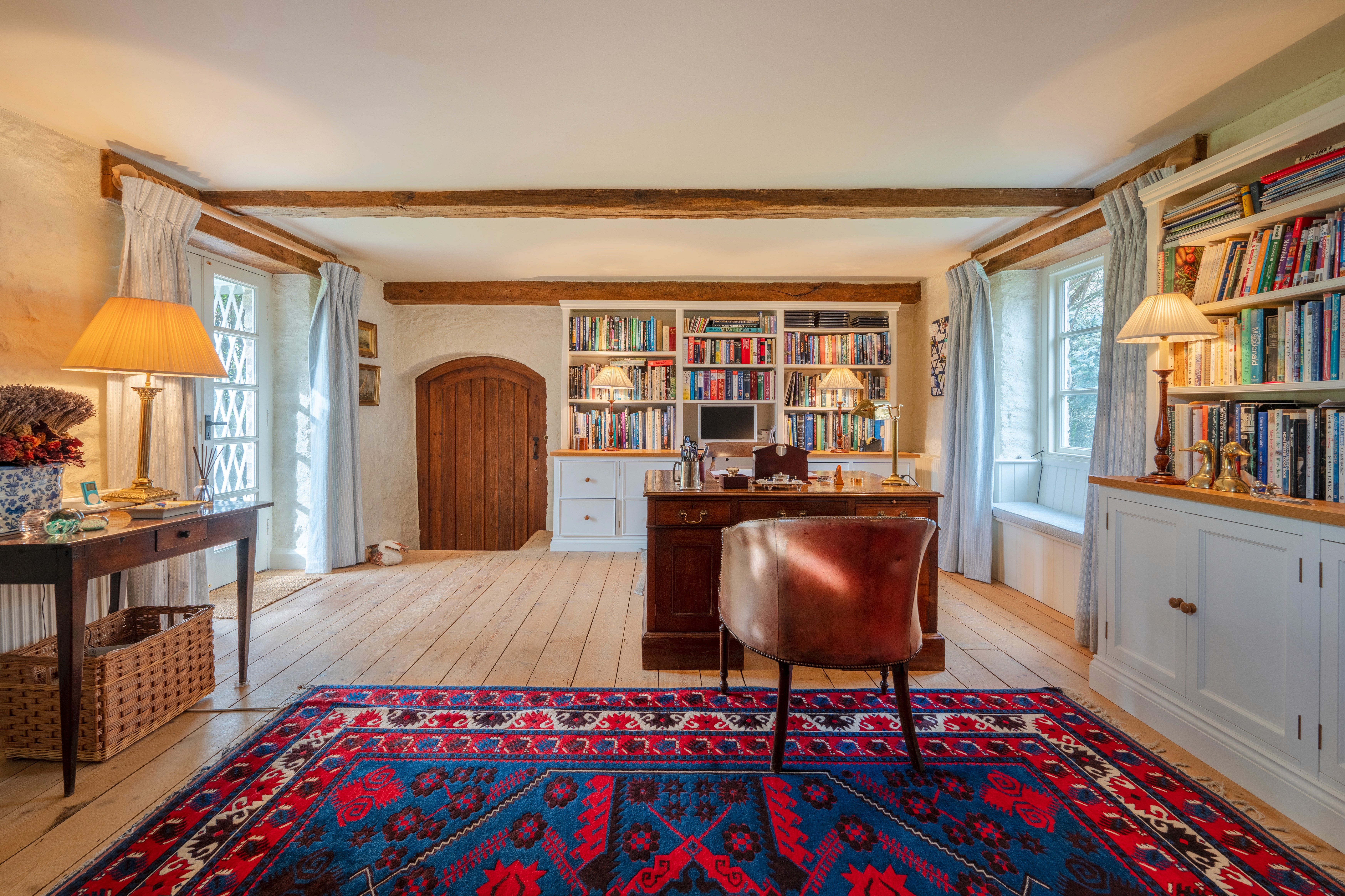 Home library with beams, bookshelves and wooden floor