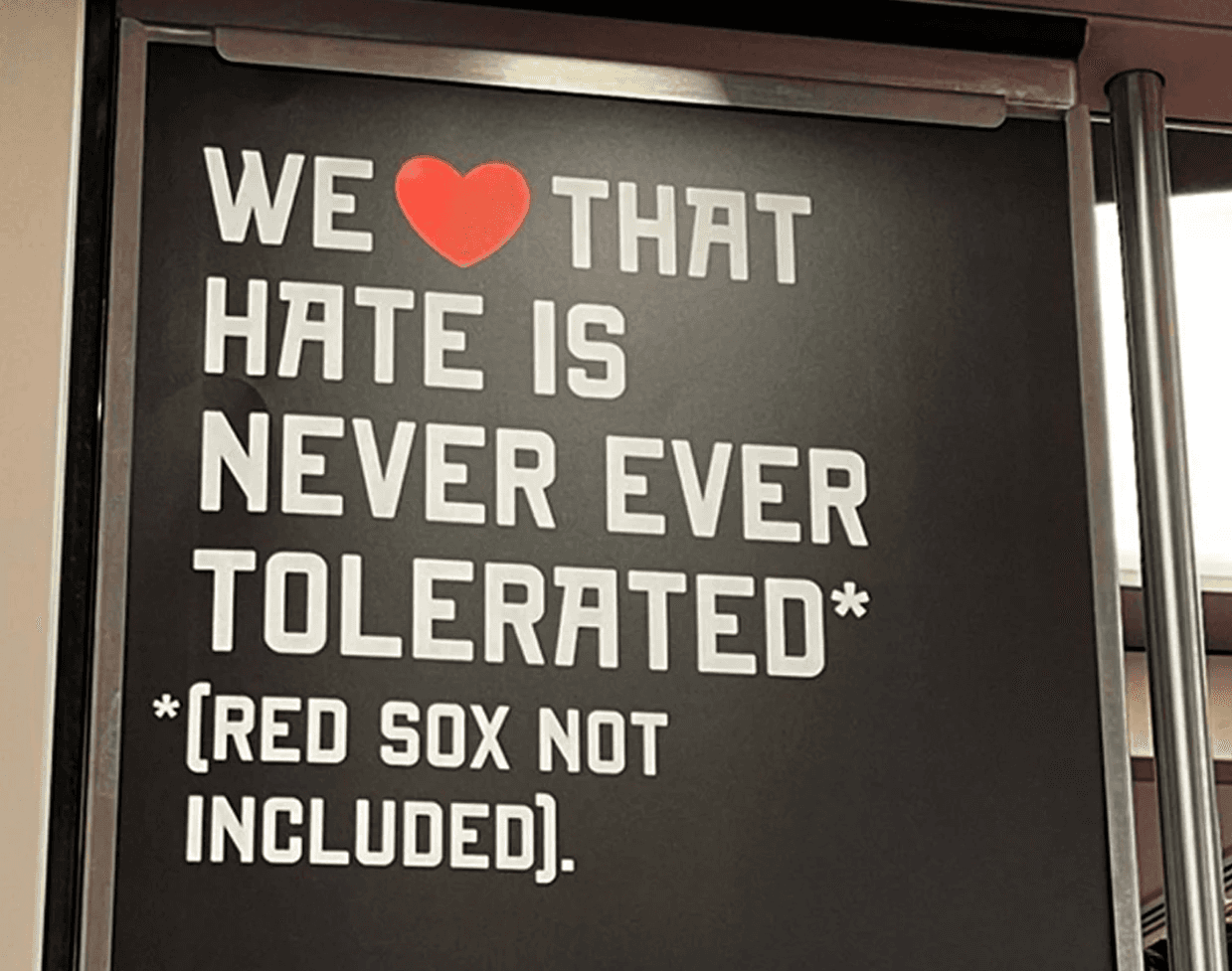 Black poster with white text "We love that hate is never tolerated* *(Red Sox not included).