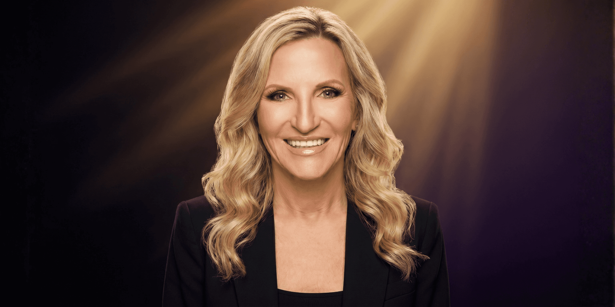 Portrait of Jessie Tylre Williams smiling under spotlight, symbolizing resilience, recovery, and personal transformation.