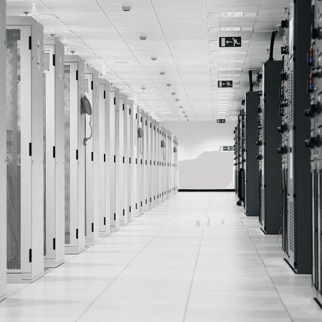 A winding road cuts through rocky terrain, surrounded by patches of green grass and illuminated by sunlight.