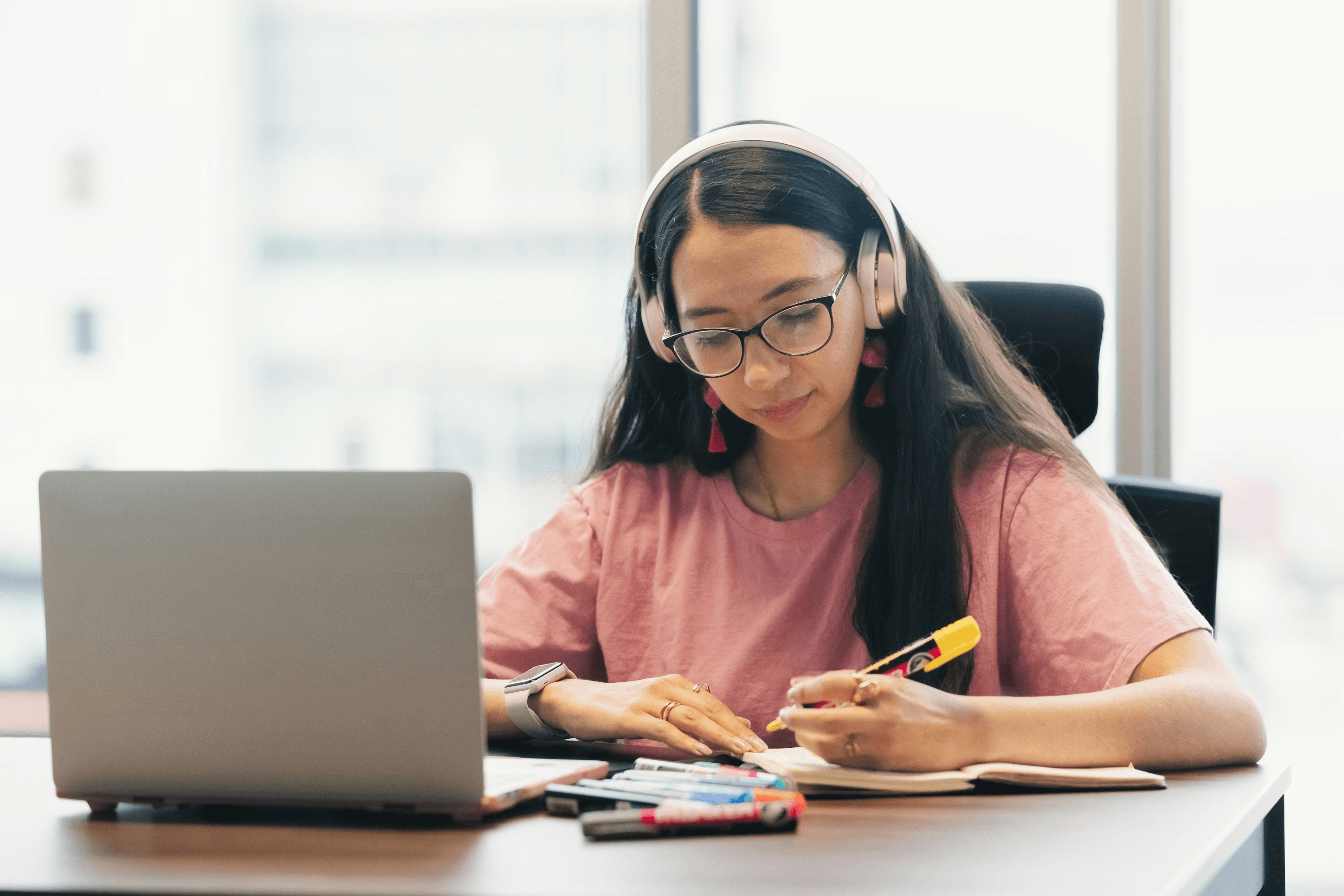 High school student reviewing research methodology options at a desk with academic journals and a laptop