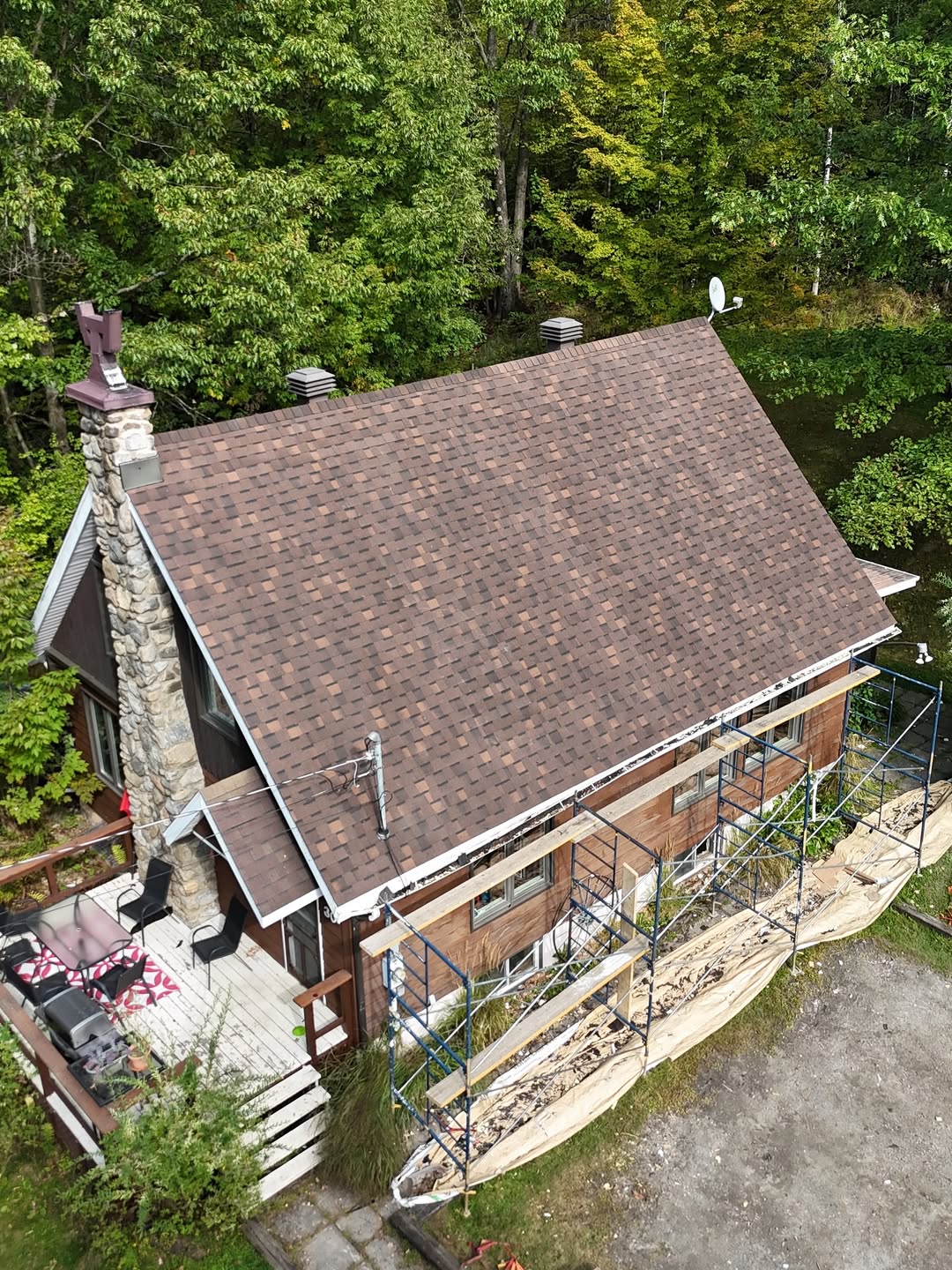 Toiture résidentielle en bardeaux d’asphalte brun installée sur une maison unifamiliale, vue aérienne après les travaux