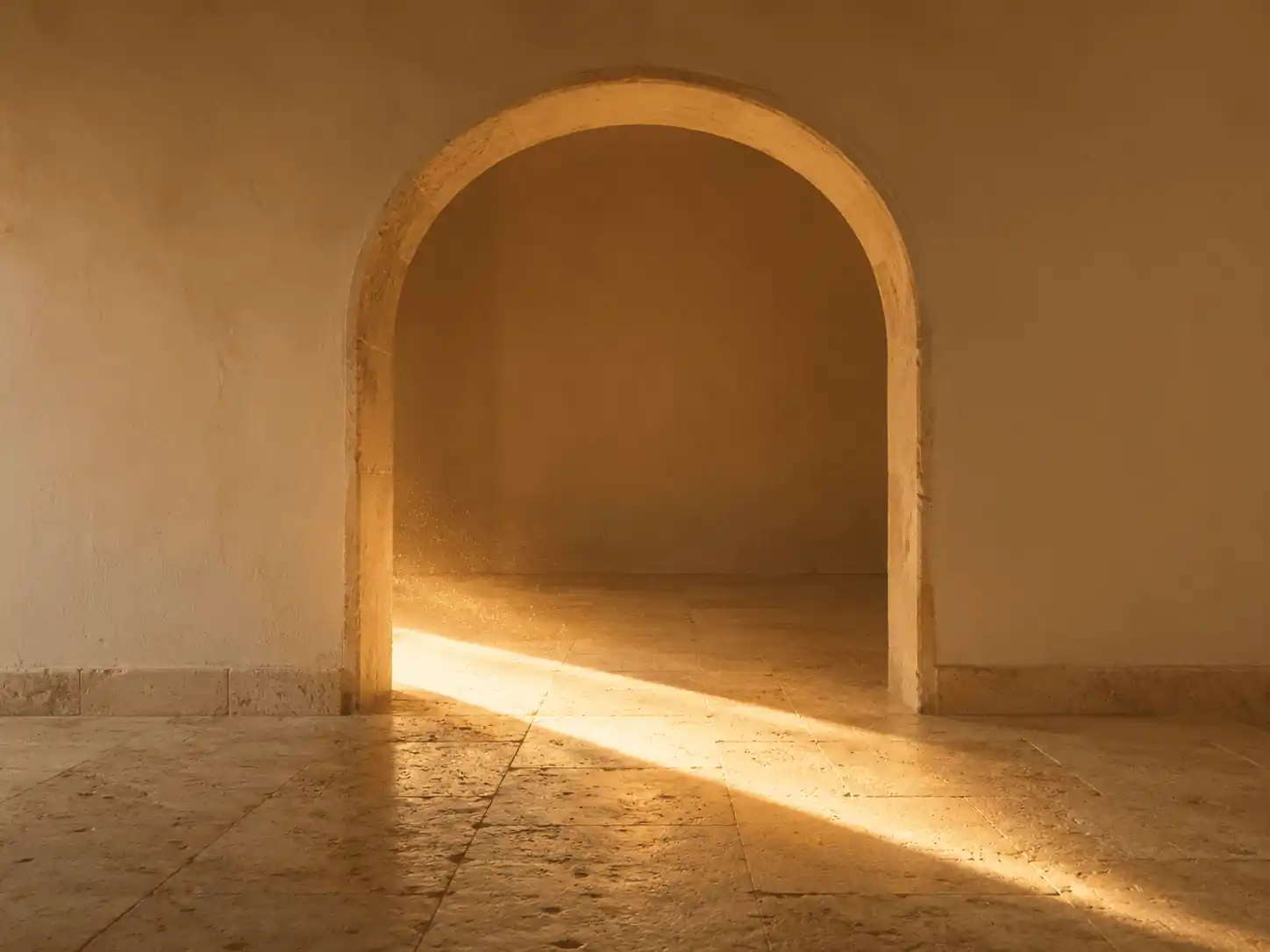A single band of sunlight crossing a stone floor through an open doorway