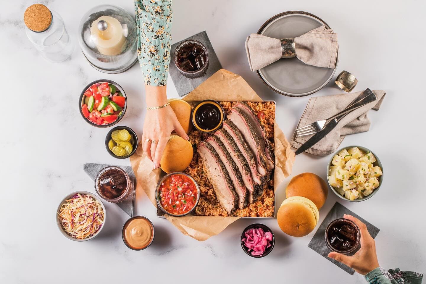BBQ restaurant dubai featuring classic barbecue sides including white bread, potato salad, coleslaw, and slow-cooked smoked beans.