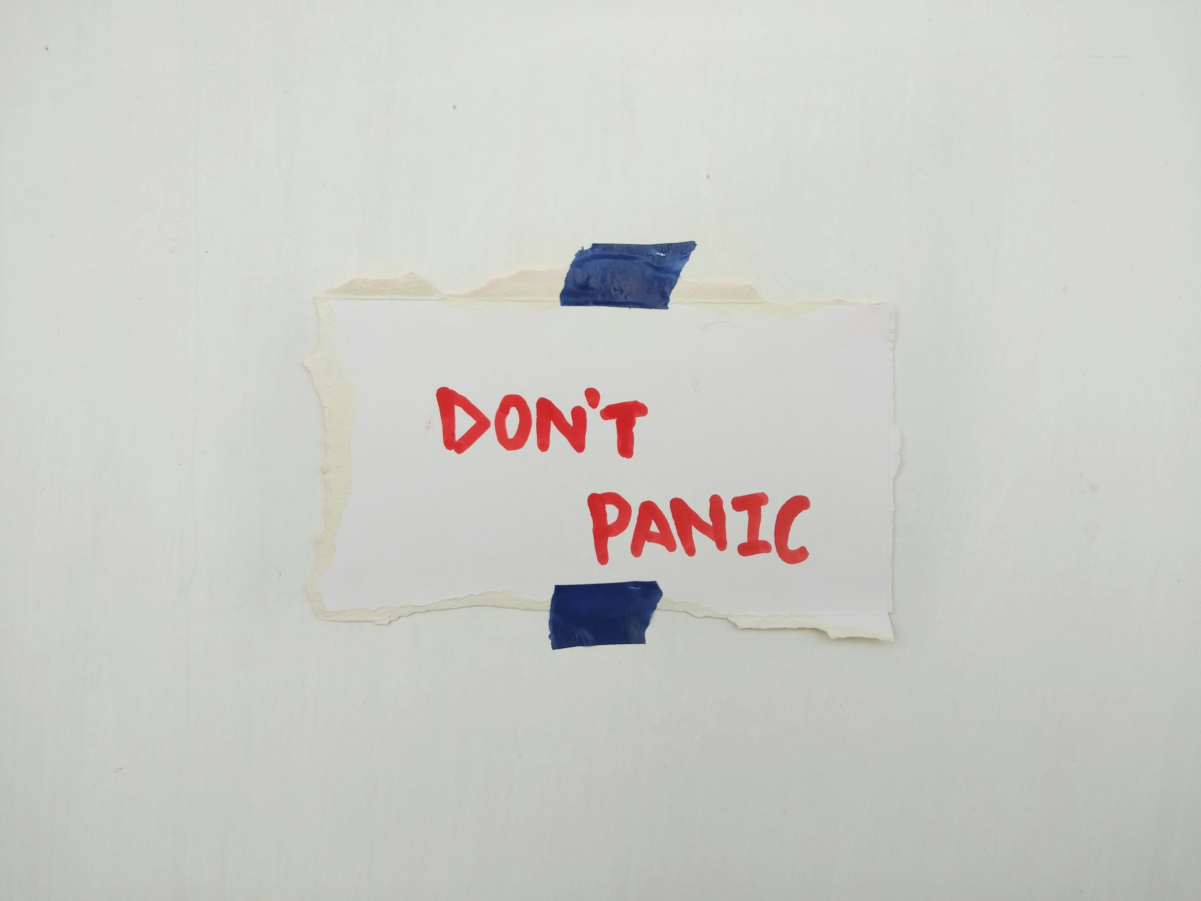 A ripped up piece of paper that says 'don't panic'