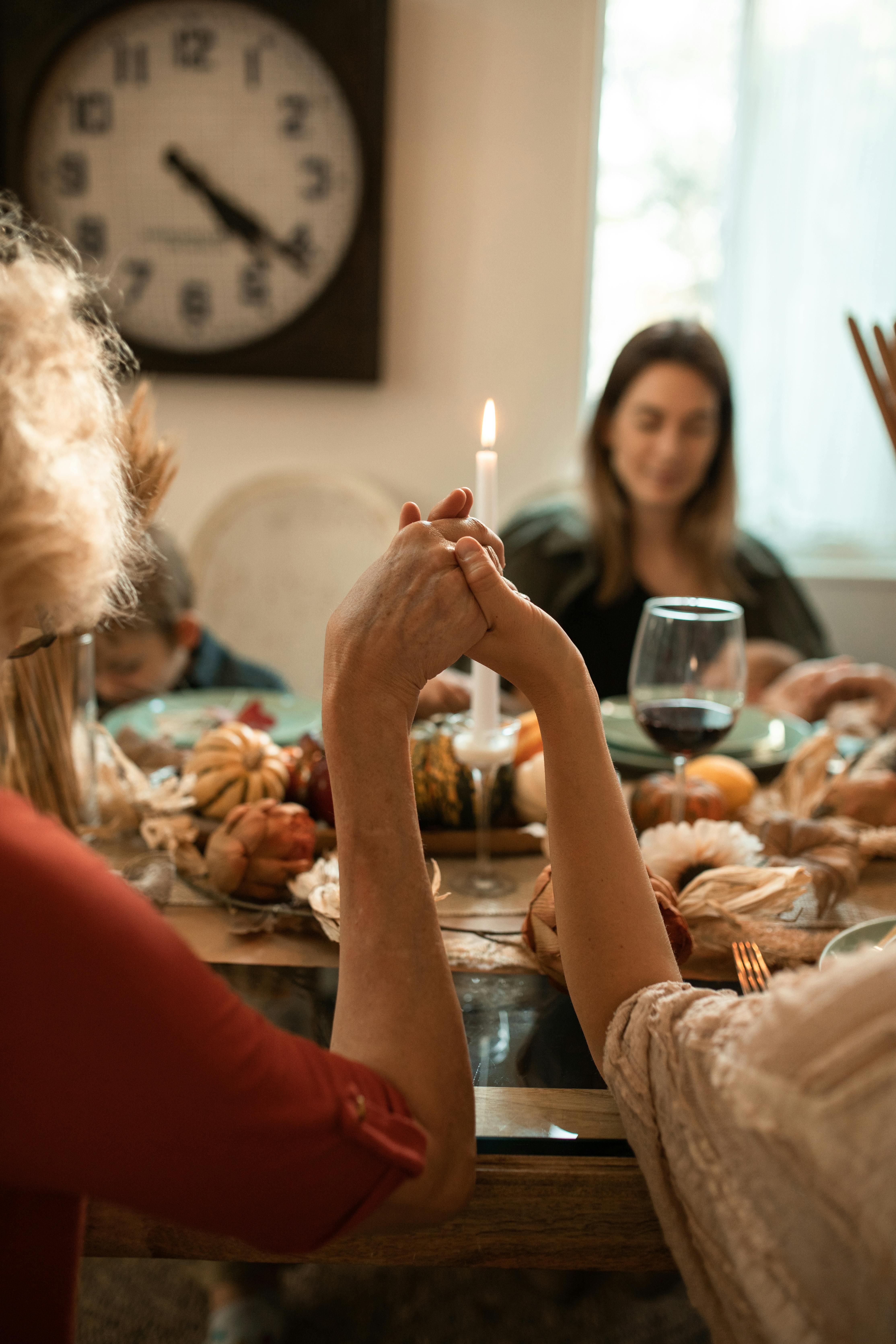 Conversion Truth for Families - A family holding hands, gathered around a table with dinner on the table