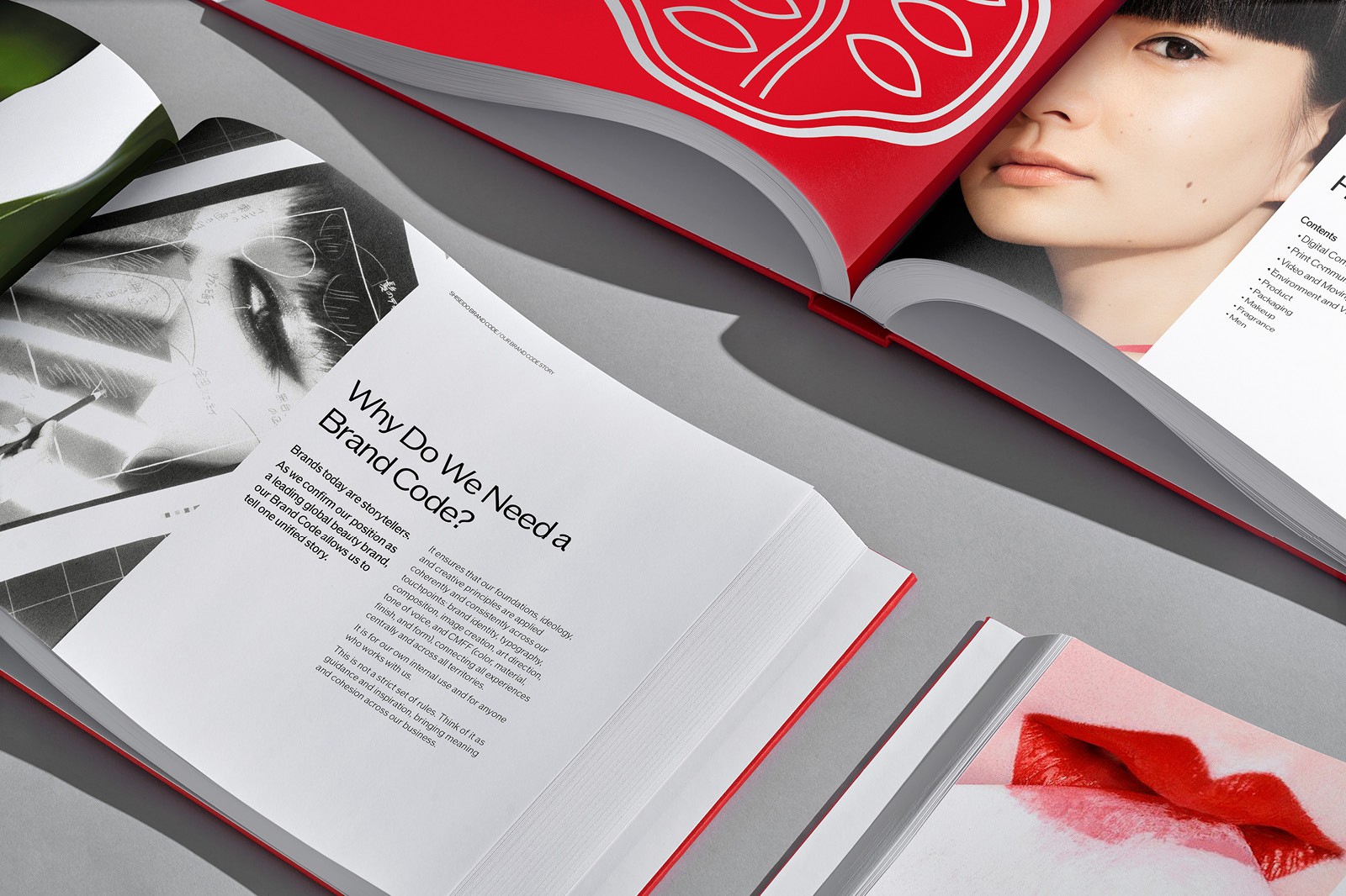 A close-up of an open magazine and a book, featuring text and a red accent, on a light surface.