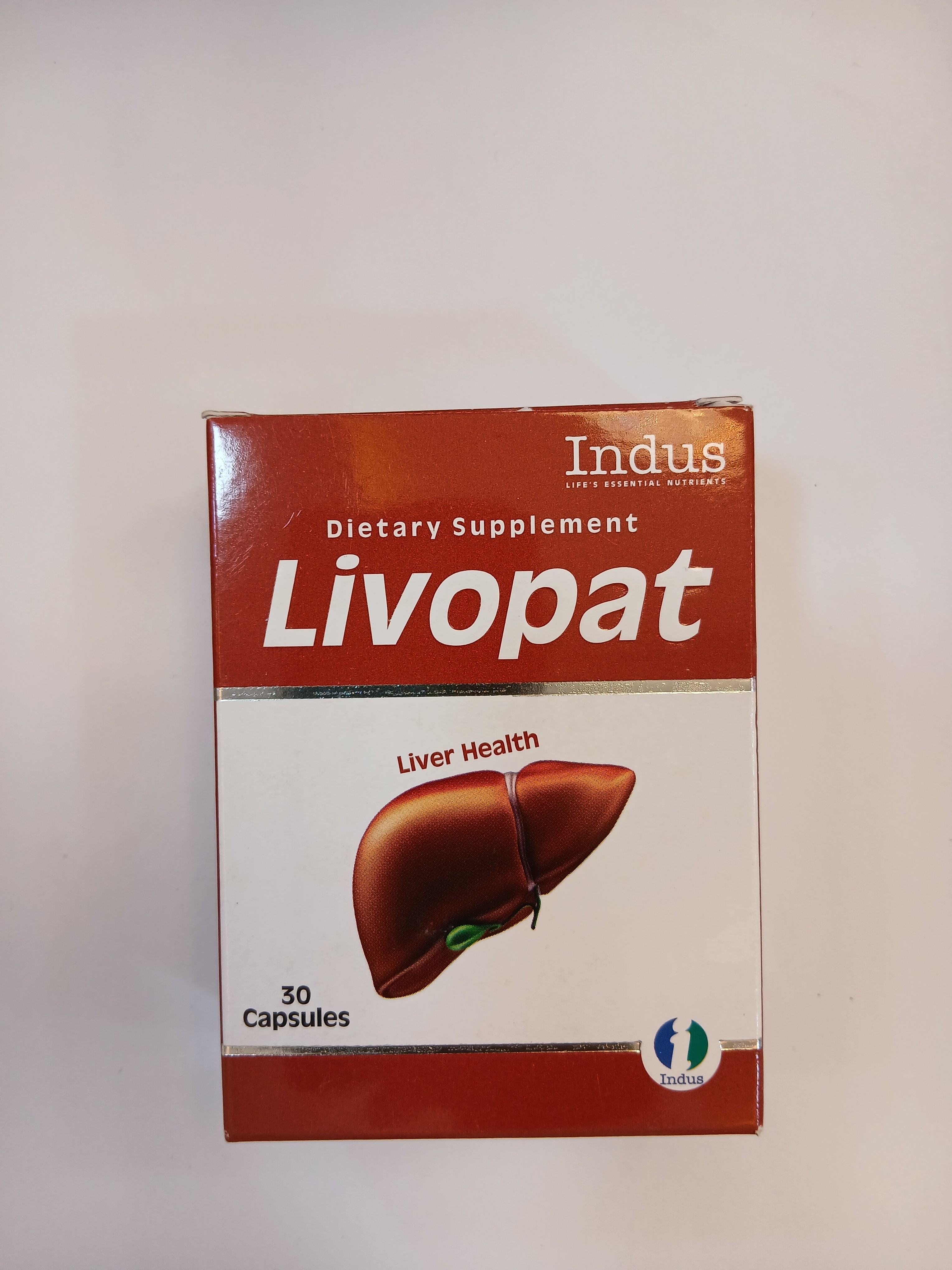 A red and white cardboard box packaging displays a graphic of a liver with green veins, labeled as a dietary supplement containing 30 capsules.