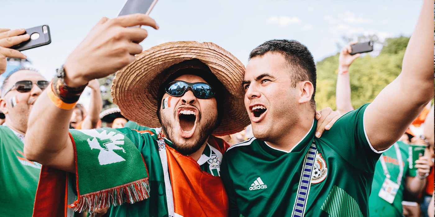 Dos hombre con la camiseta de México celebrando