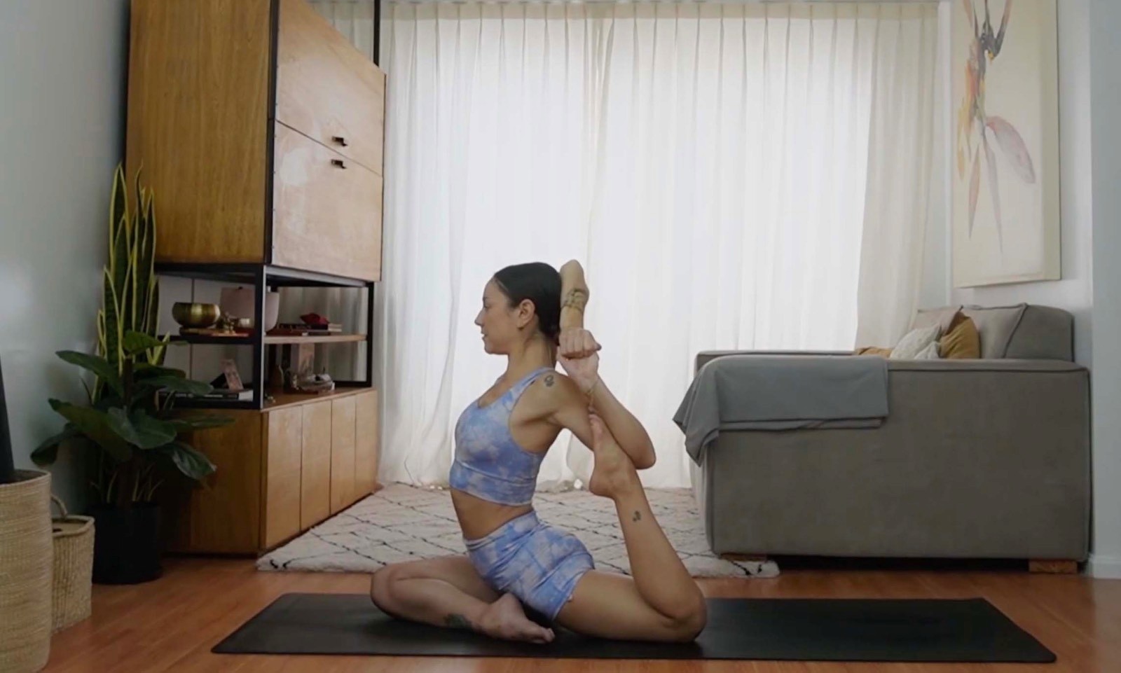 Flavia Siutti practicando una postura de apertura de pecho sentada sobre la esterilla.