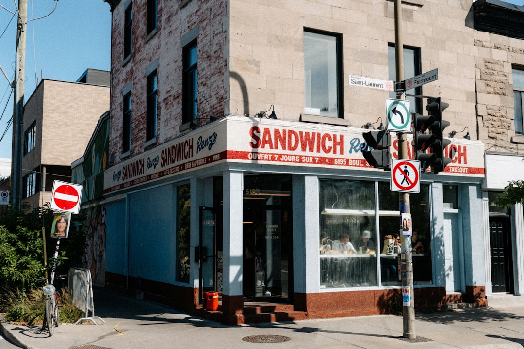 Corner sandwich shop with blue windows and red signage