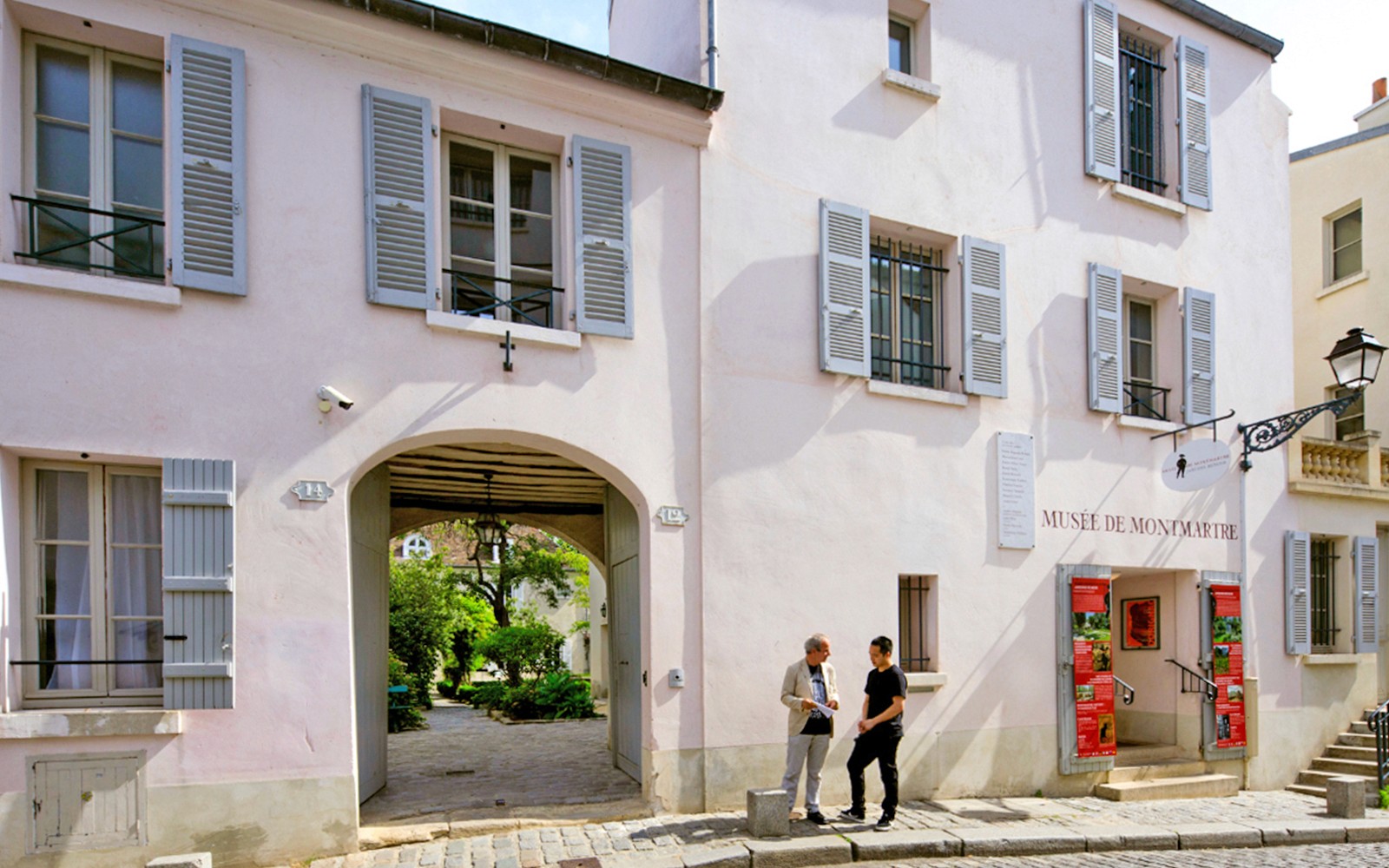 巴黎蒙马特博物馆入口处，两个人在外面交谈。