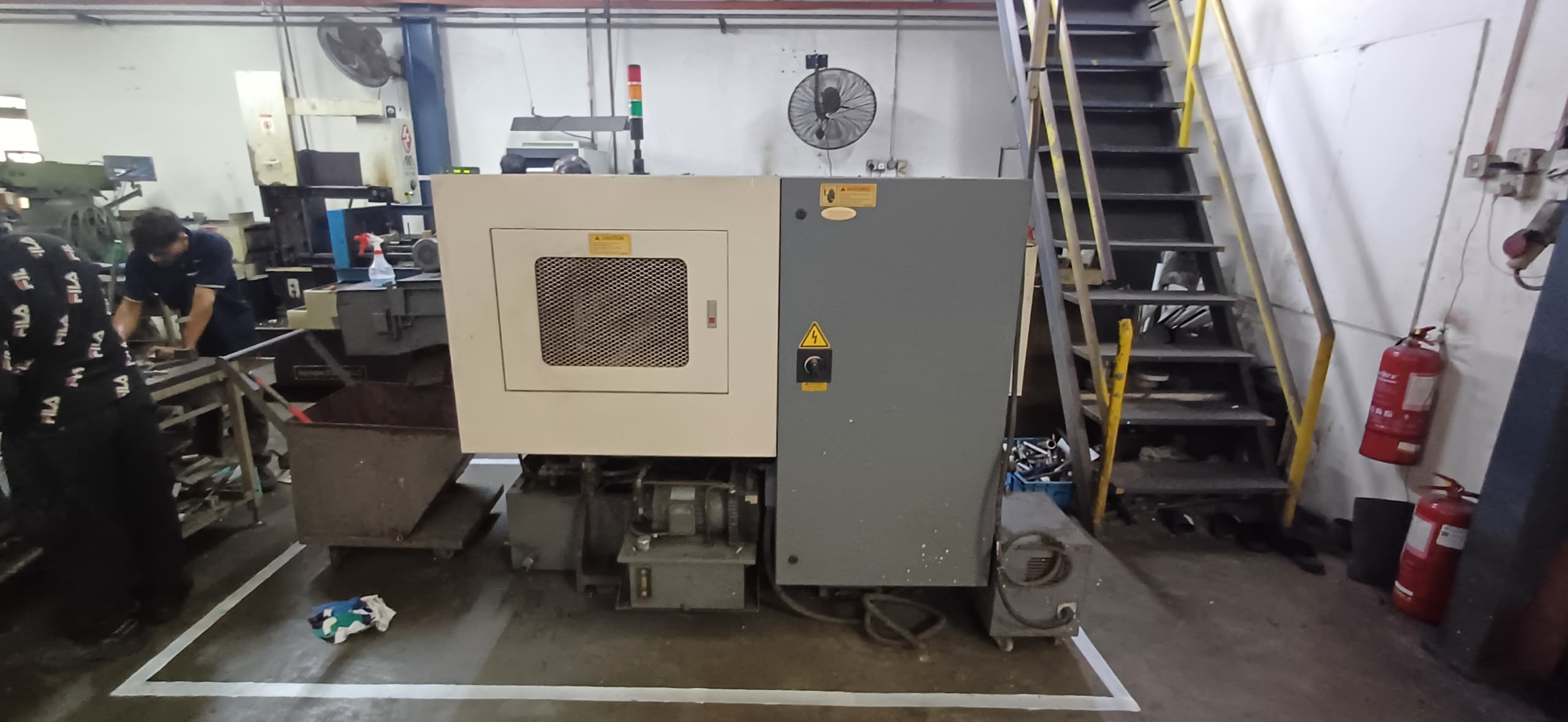 After 5S implementation: Production machine on a clean, designated floor space (marked by lines), demonstrating improved workplace organization.