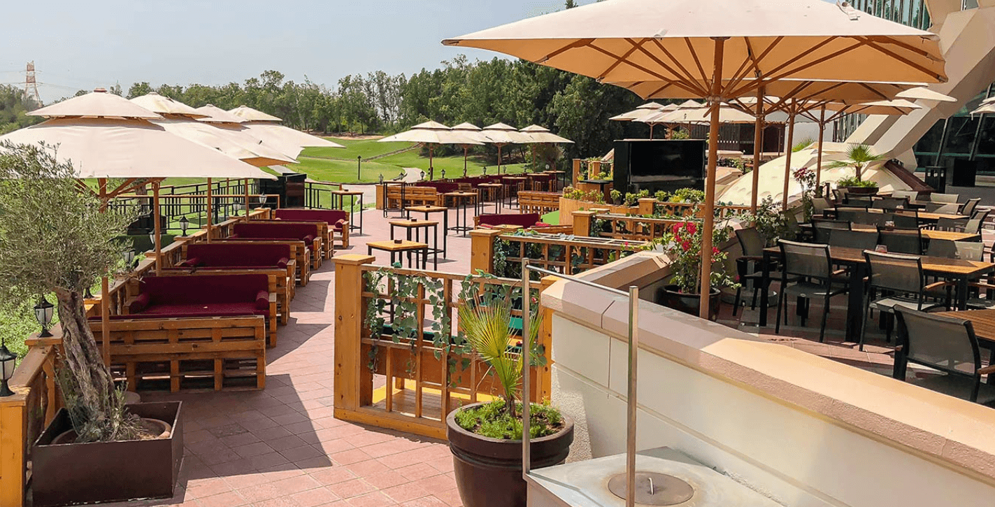Outdoor patio area of a hotel in Khalifa City, featuring seating and greenery for guests to enjoy the fresh air.