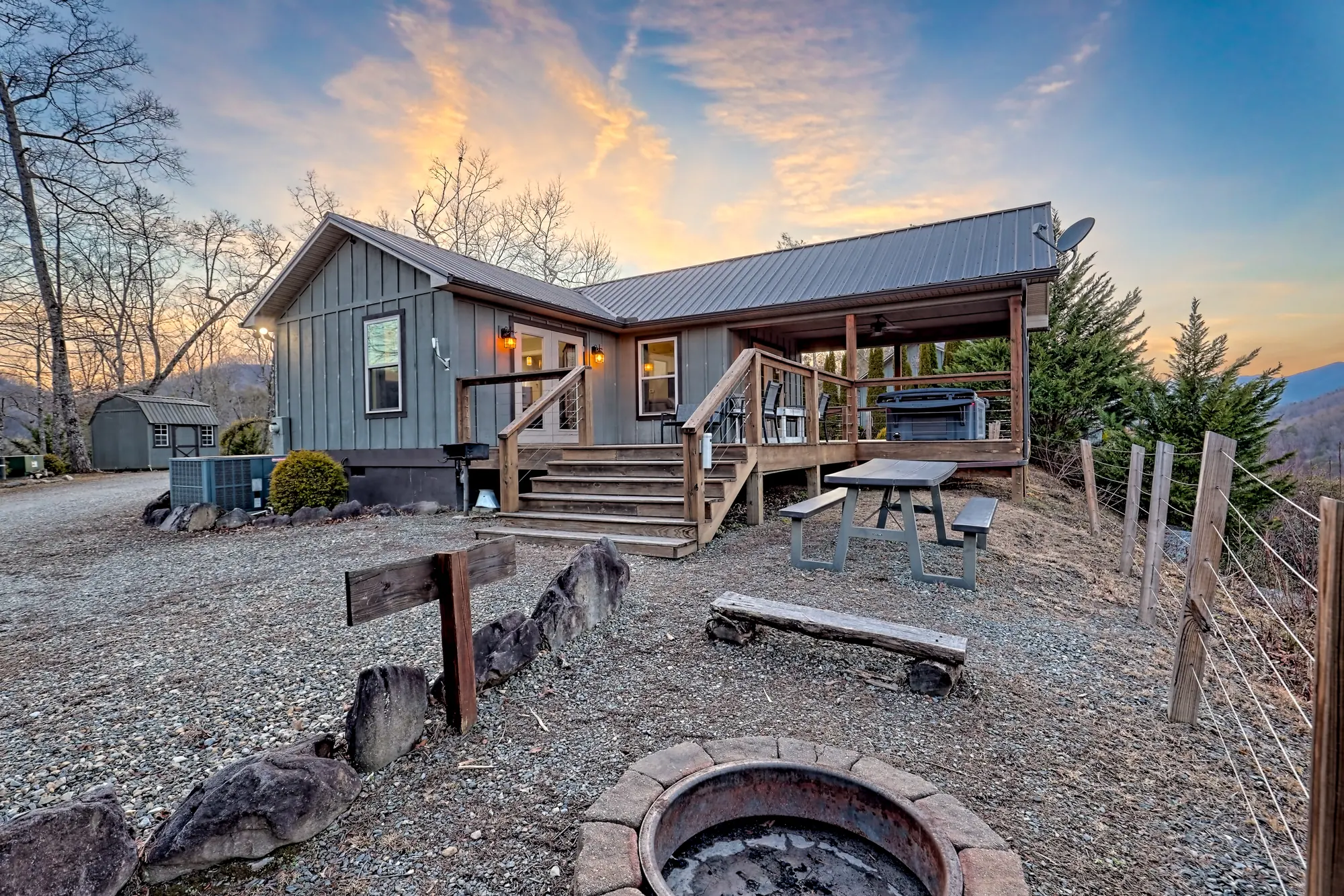 Eagles Nest at sunset with the deck stairs, fire pit and picnic table