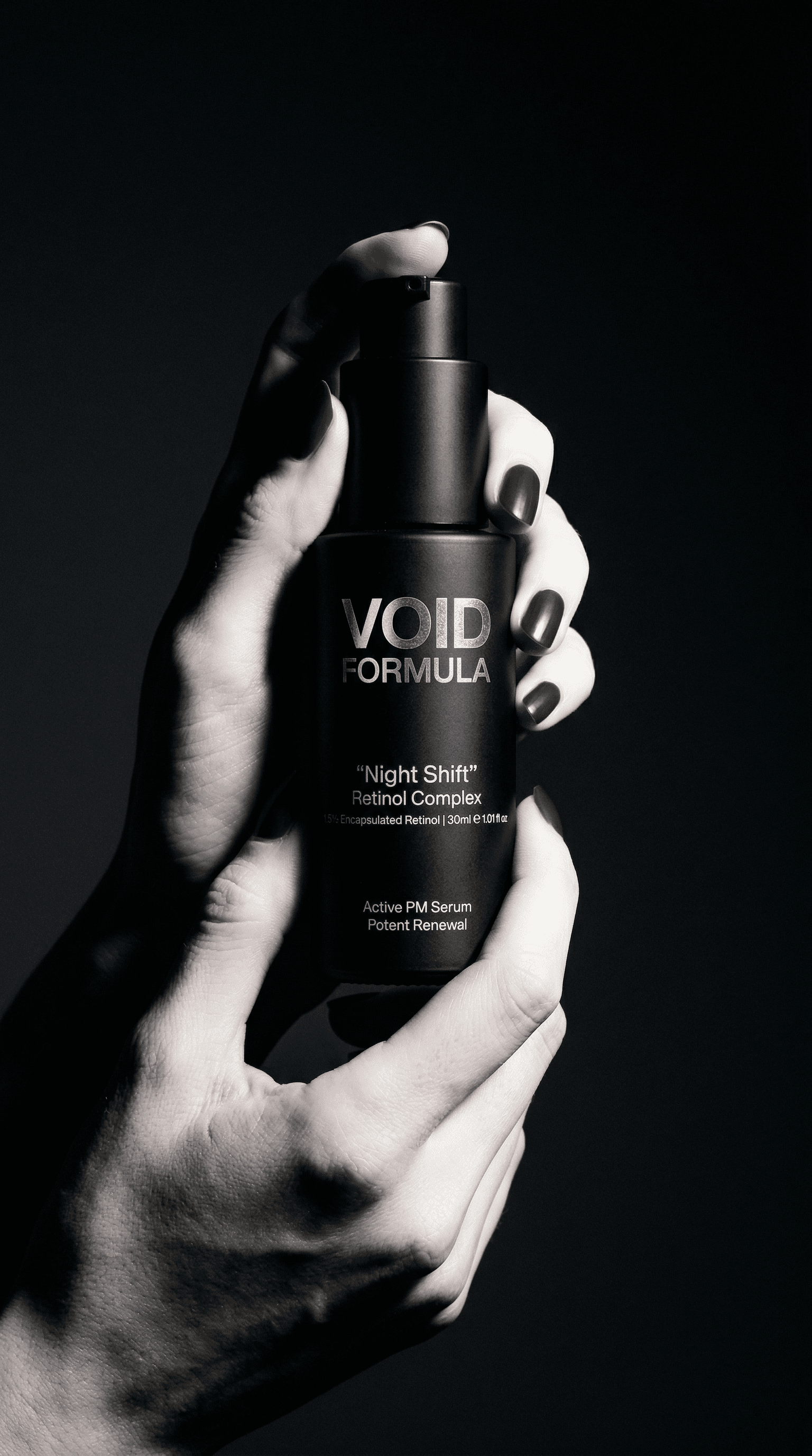 Void Formula Night Shift retinol serum bottle held in hands on dark moody background