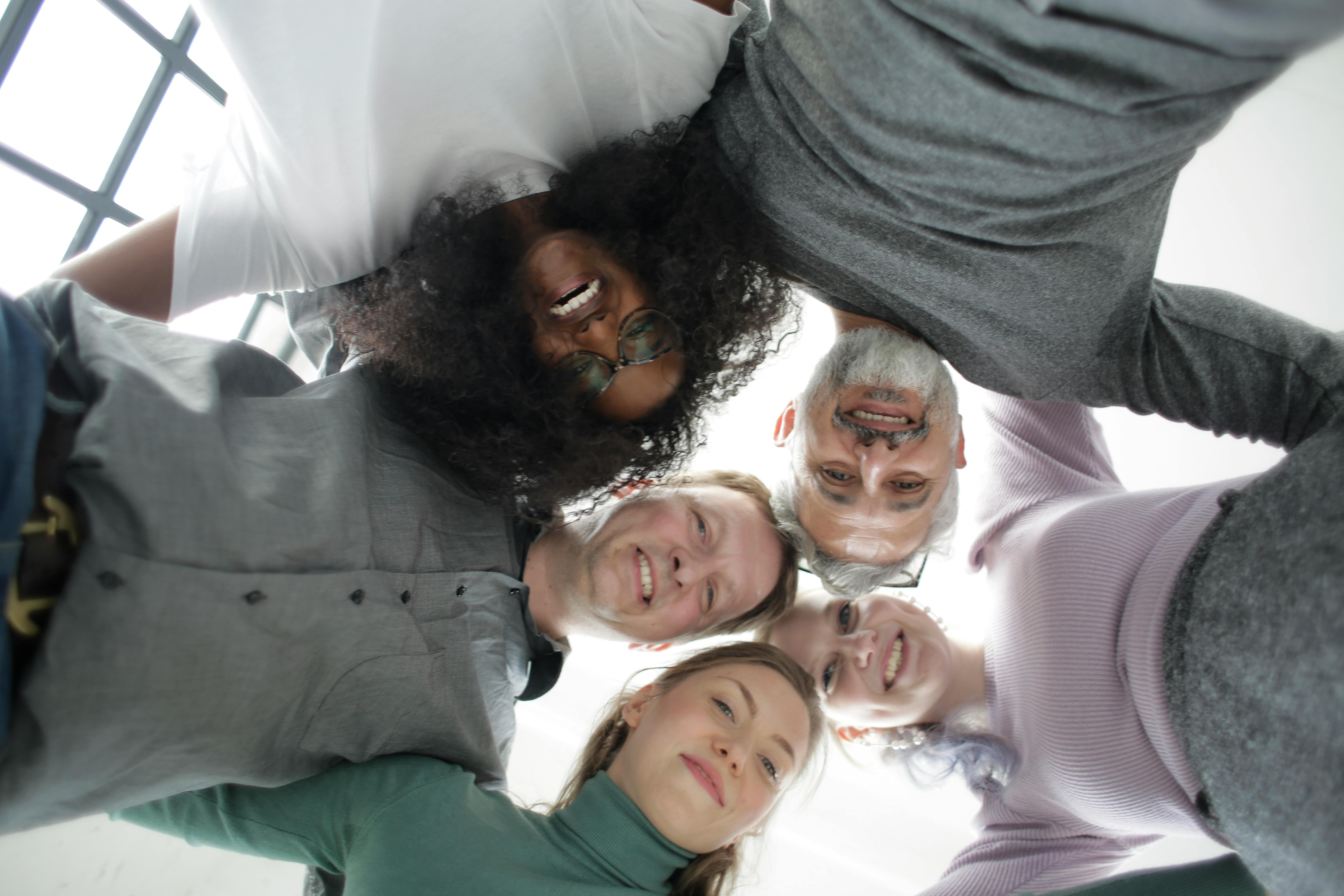 Group of people side hugging and looking at the camera