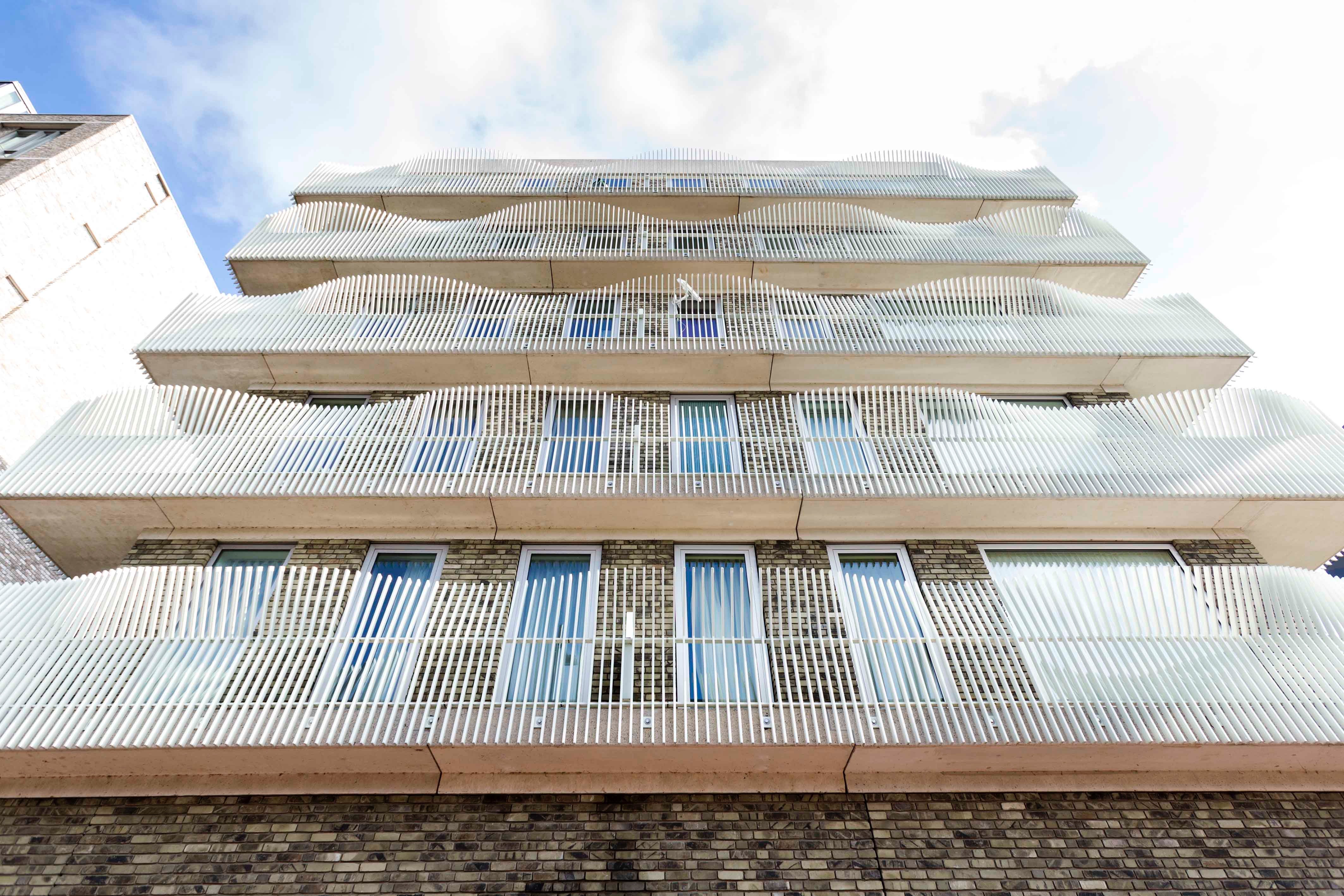 Een gebouw met opvallende golvende witte balkons, strak en modern design.