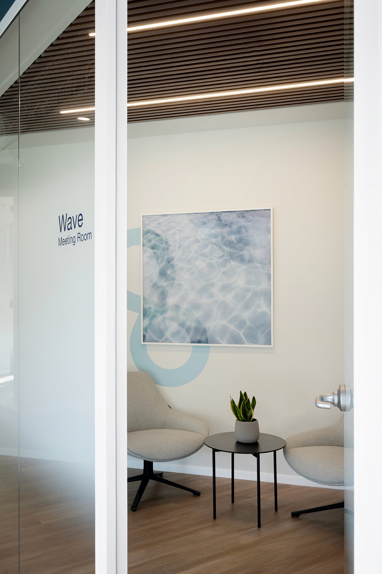 חדר שקט (Focus Room) לשיחות פרטיות: שילוב גרפיקה סביבתית בהשראת טופוגרפיה של מים וריהוט רך לאקוסטיקה משופרת