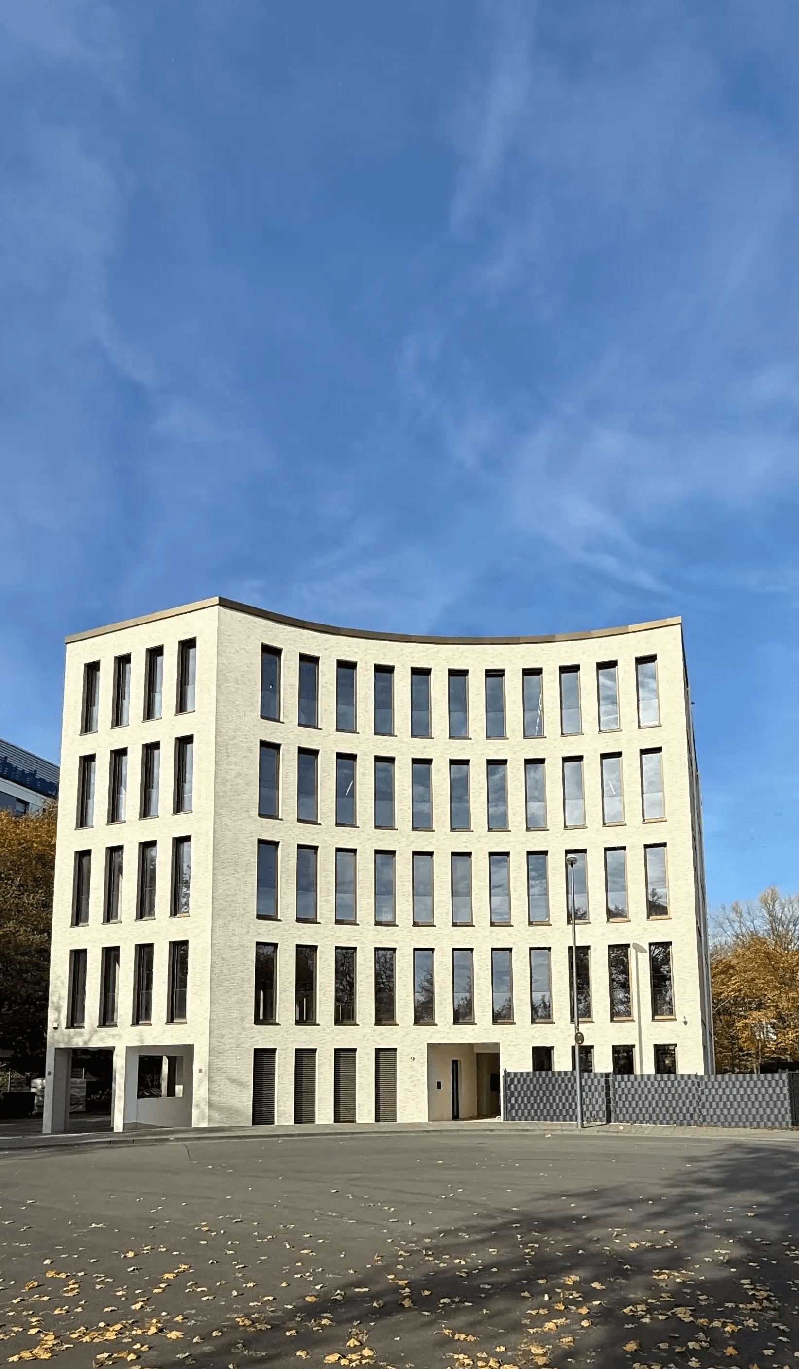Das Bürogebäude DEUTZ ONE in Köln-Deutz, Sitz der AS Projekte GmbH – modernes Verwaltungsgebäude mit heller Fassade und großflächigen Fenstern unter blauem Himmel.