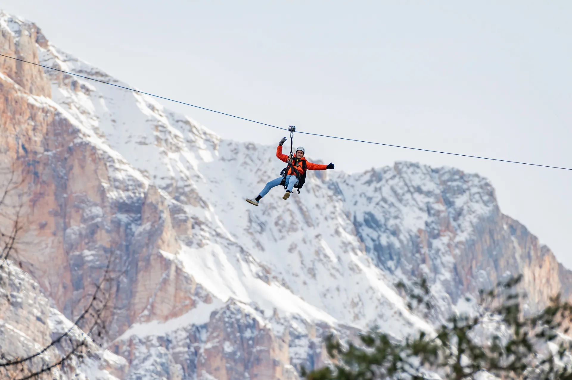 Person with open arms flying on the zipline in the woods