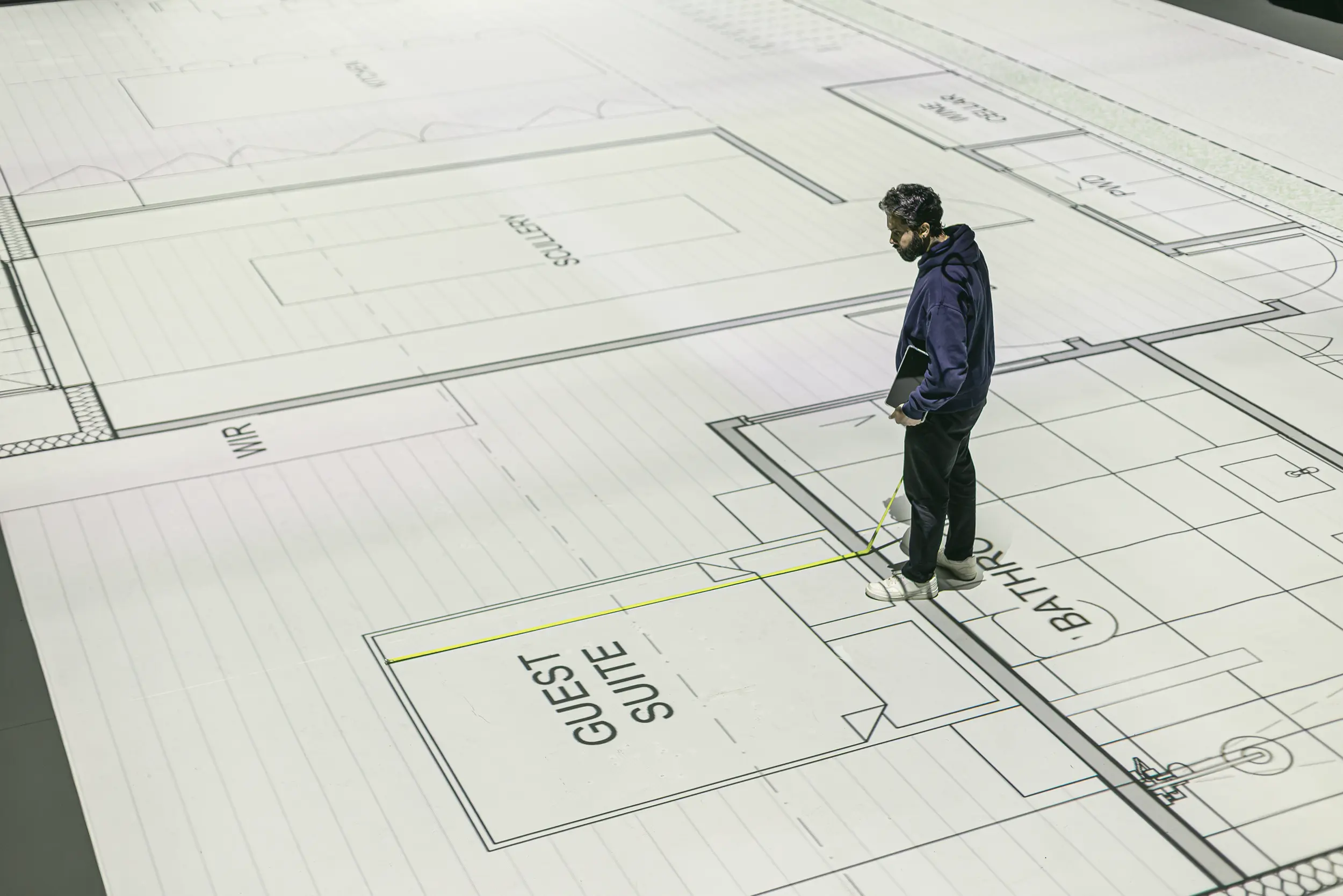 Person measuring in live-scale their projected floorplans