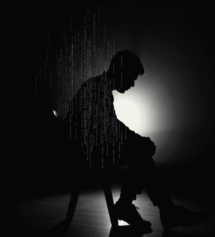 Silhouette of a seated person with cascading code