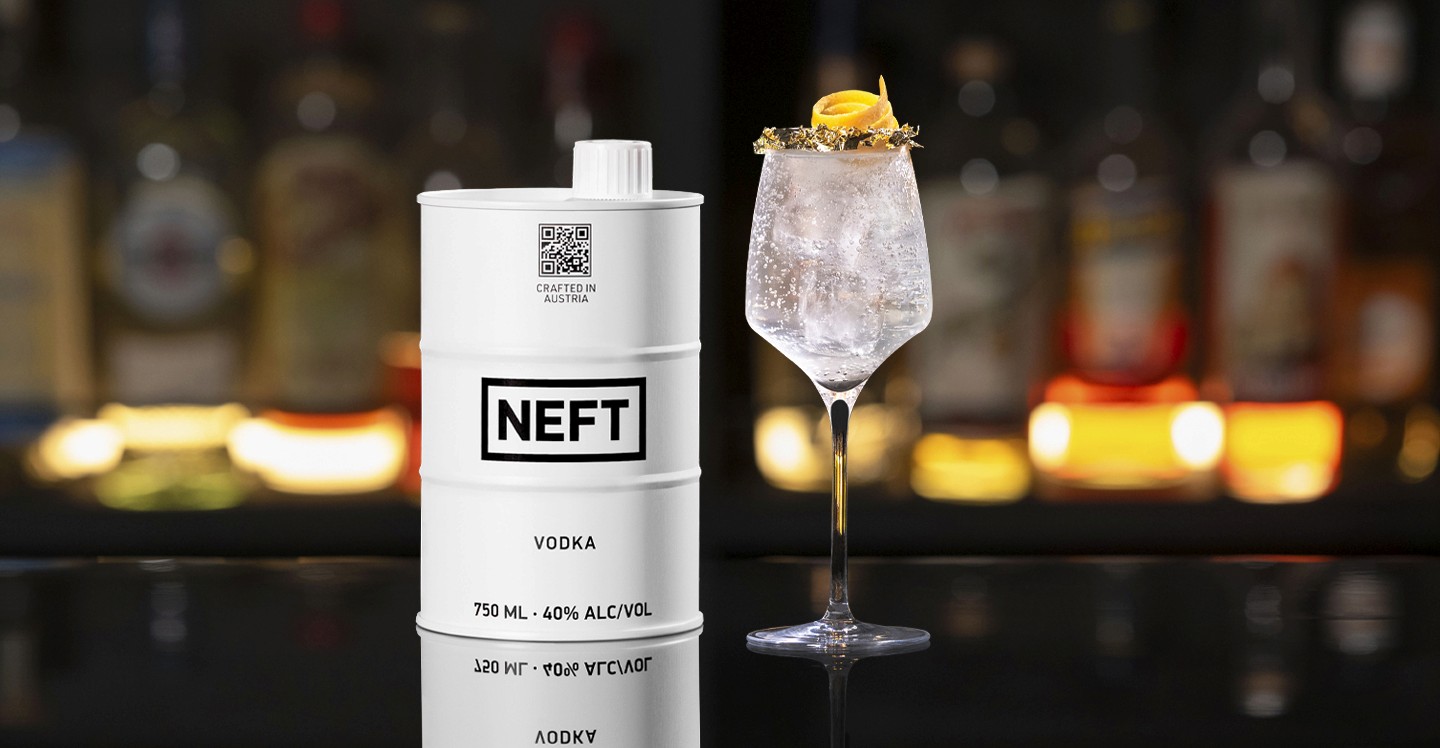 A NEFT Barrel and a glass of New Year's Effervescence on a bar counter.