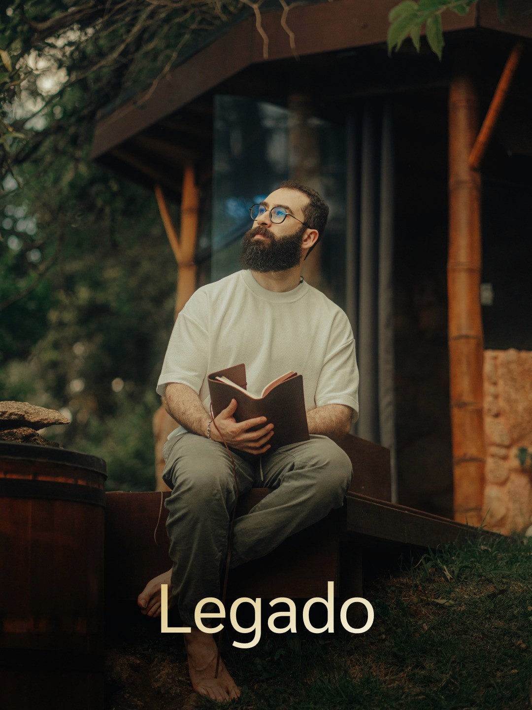 Dirt road flanked by vineyards and cypress trees, rolling hills, mist, and distant town in Tuscany.