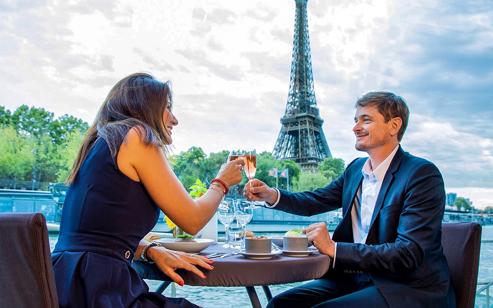 夫妻在巴黎的新年前夜2025年游船上举杯庆祝,享受埃菲尔铁塔美景。