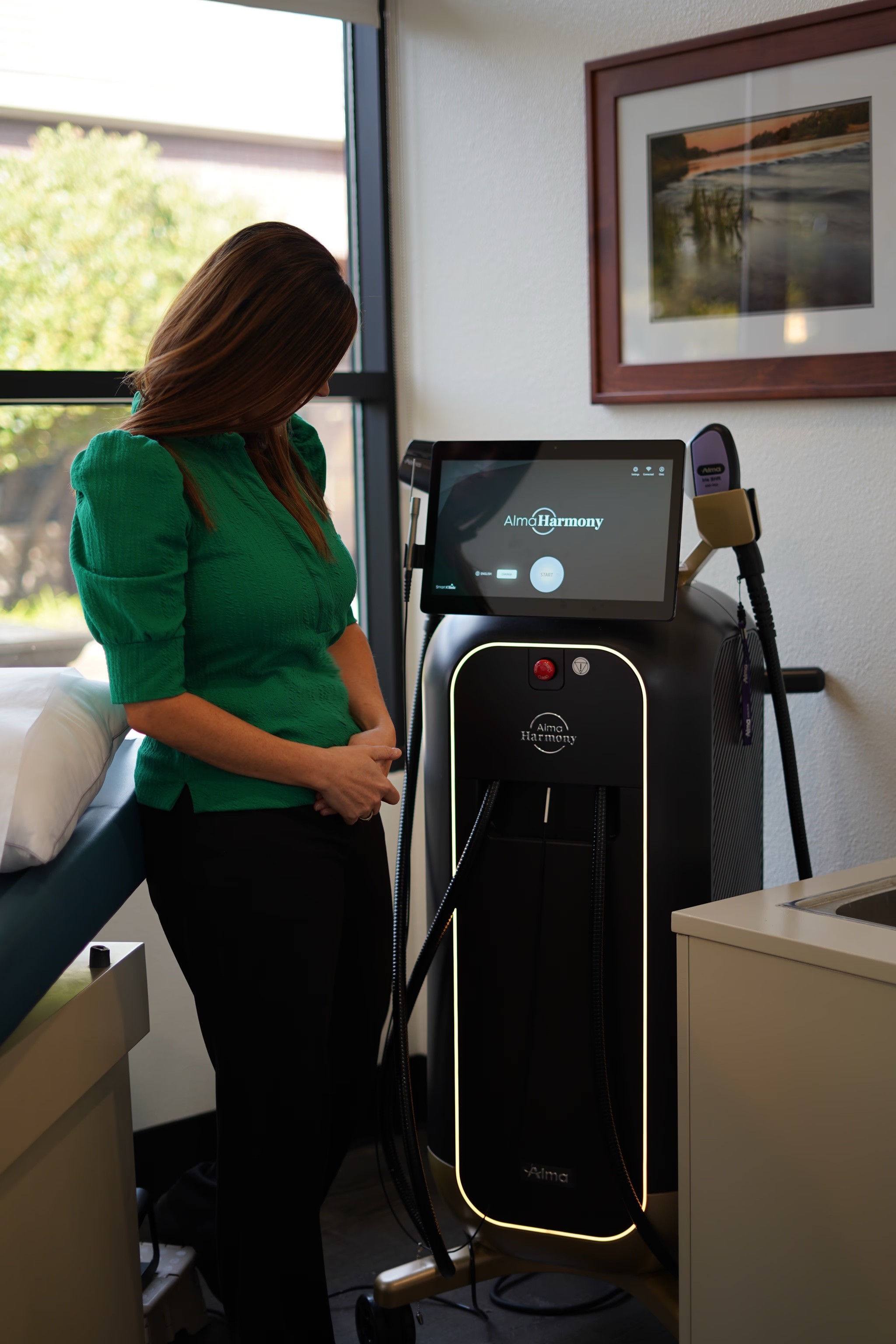 Doctor standing nearby the Alma Laser Harmony Equipment