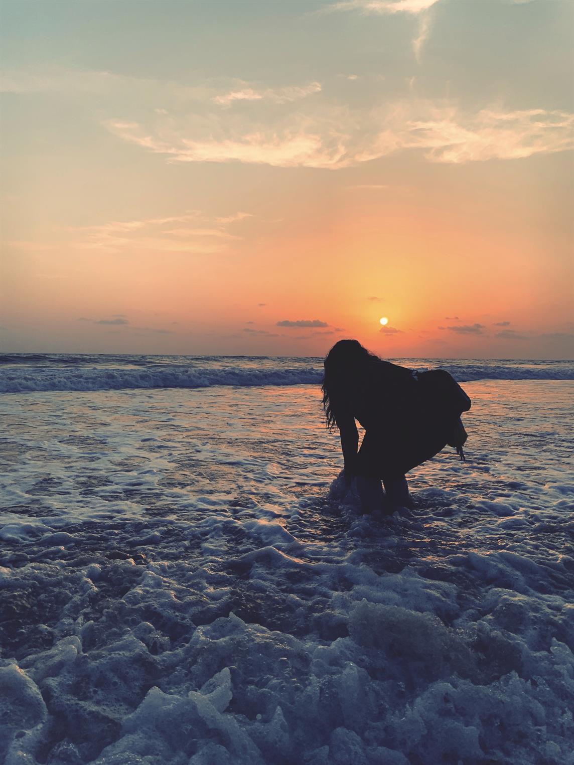 sitting woman carrying backpack overlooking canyon during daytime