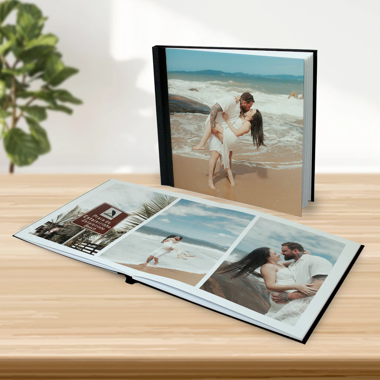 Pessoa segurando Fotolivro com foto em preto e branco de mãe beijando o filho recém-nascido, com o nome Pedro Henrique escrito na imagem