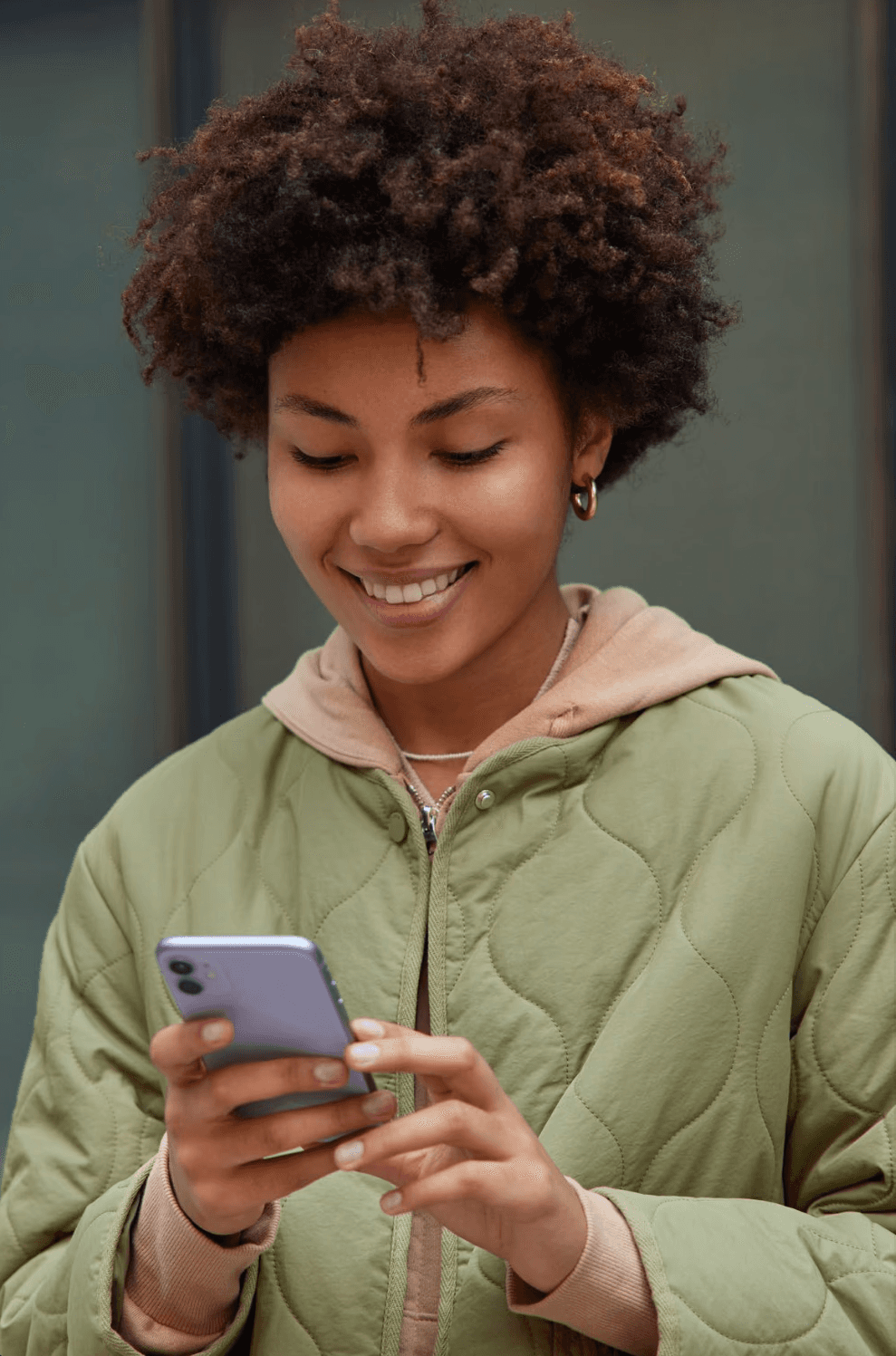 Man and woman standing together at a desk with a laptop and notebooks, smiling at the camera.