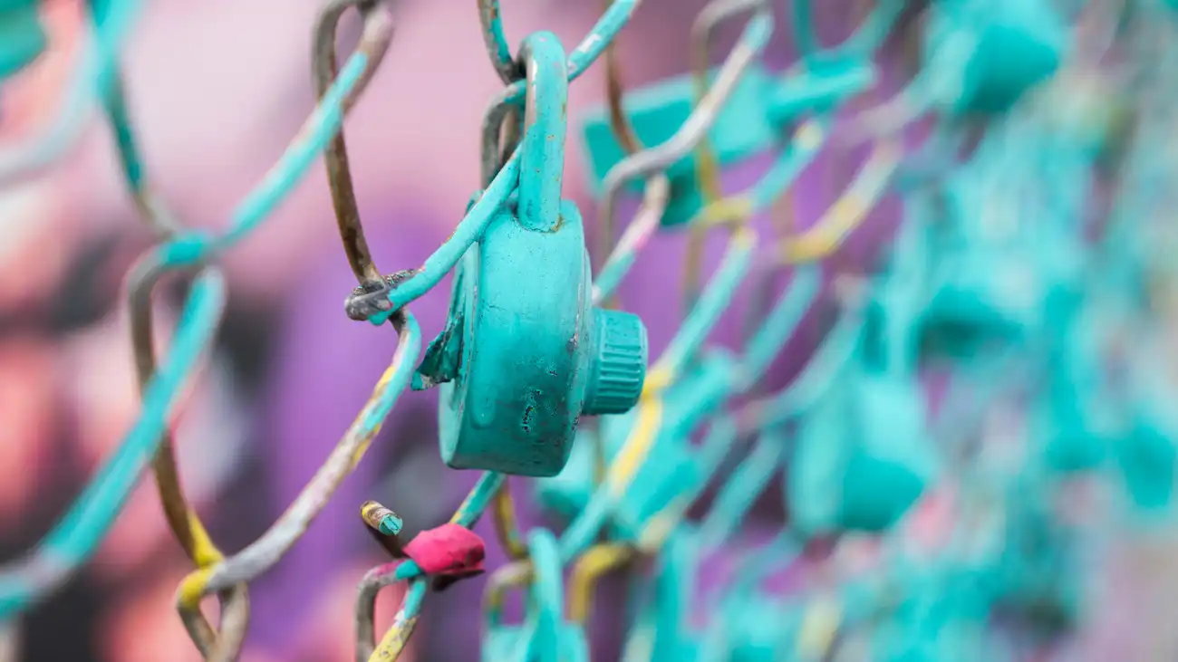 Close-up of a padlock attached to a wire fence, illustrating confidentiality, GDPR, data protection and secure reporting in sports sponsorship partnerships.