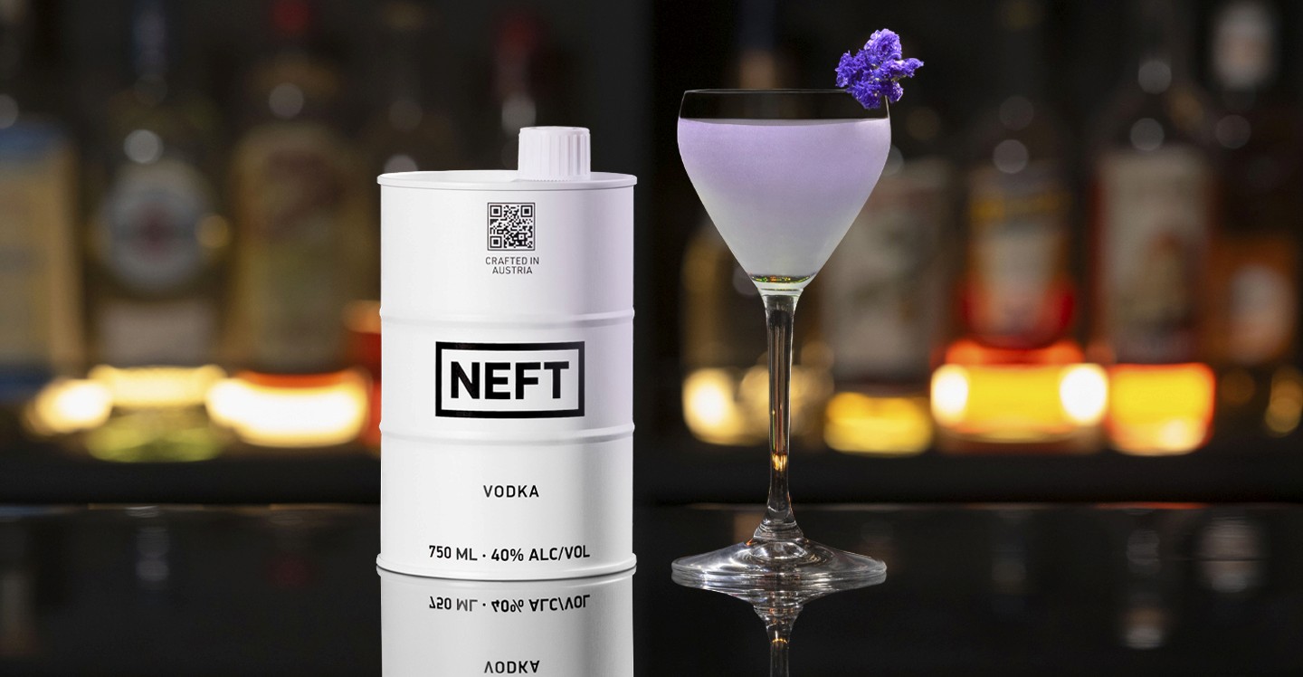 A NEFT Barrel and a glass of Violet Night on a bar counter.