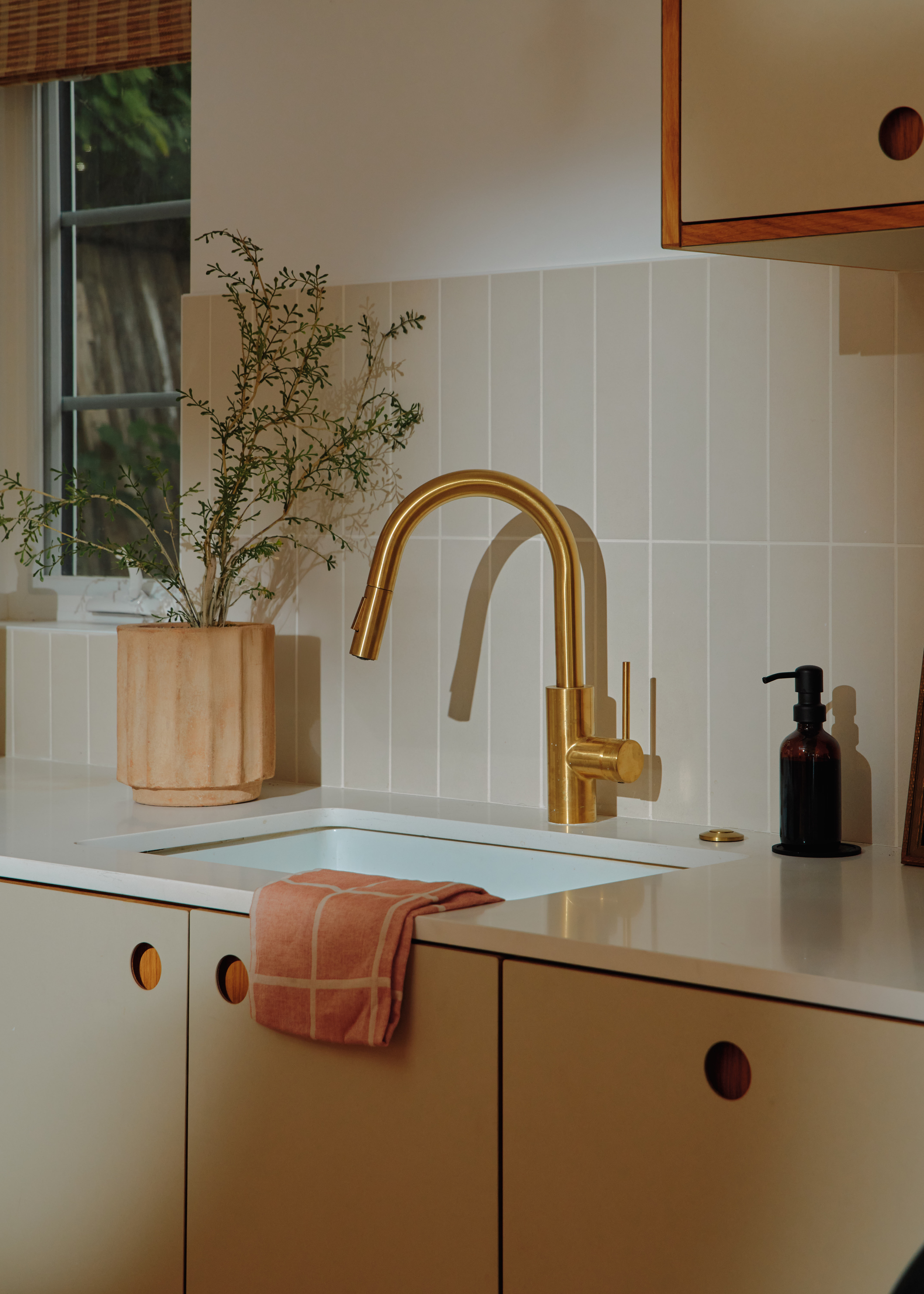 Young woman with dark hair and bangs, wearing red.