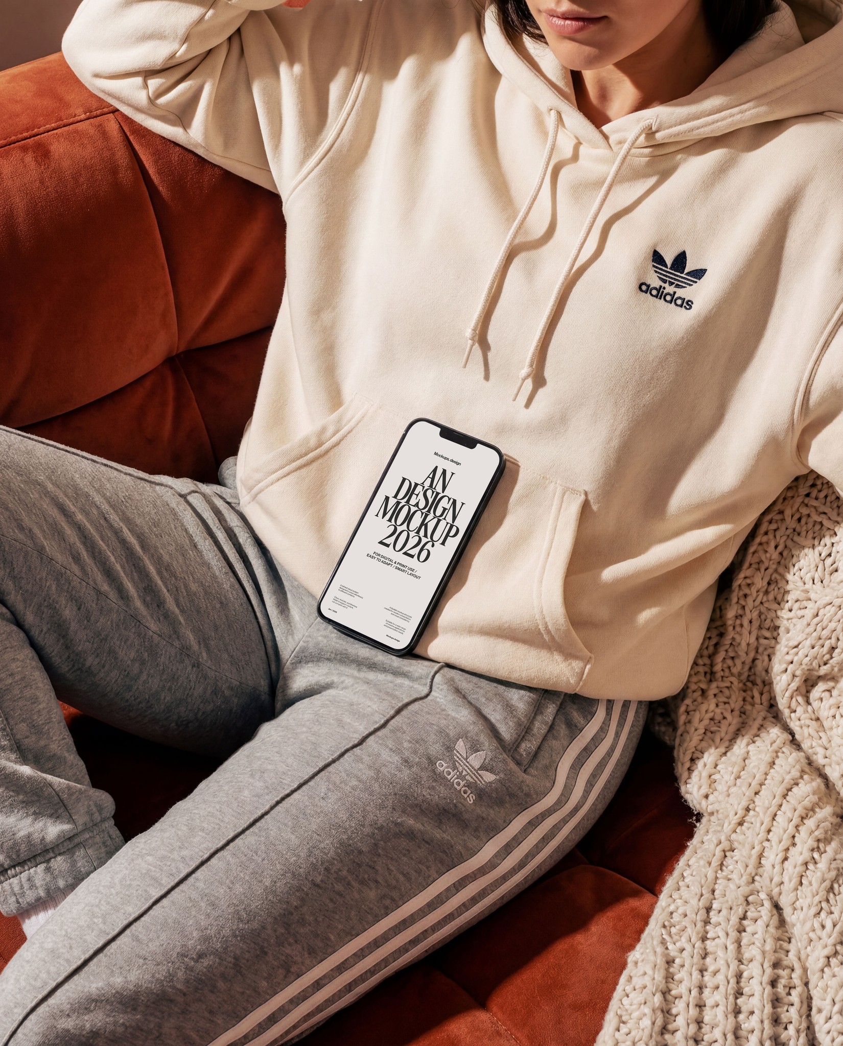 Woman using iPhone 16 mockup on couch, casual home scene