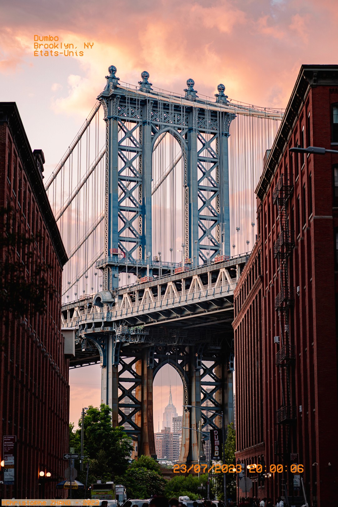 Coucher de soleil sur le Manhattan Bridge encadré par des immeubles en briques rouges à Dumbo.