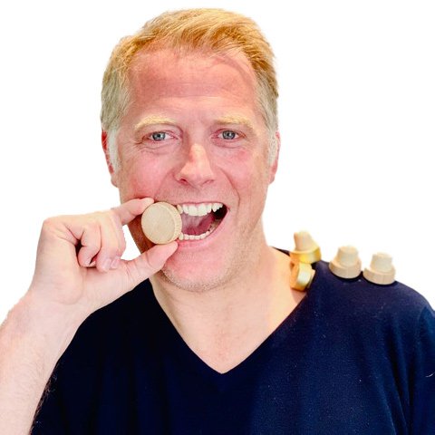 Man holding dental implant component between his teeth.