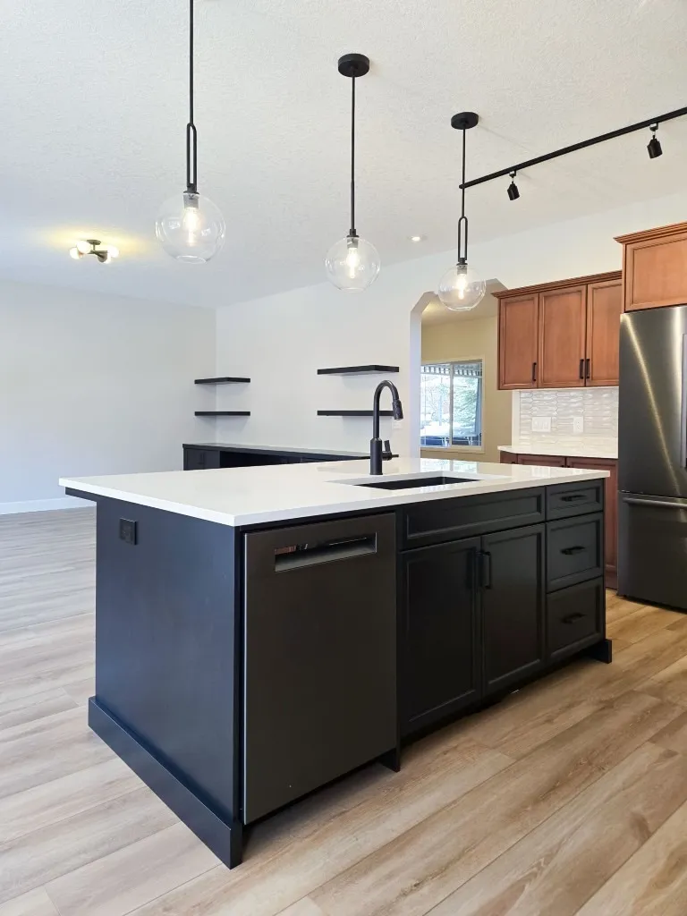 Image of Modern kitchen design with island layout, black cabinets, and white countertop by KHD Homes.
