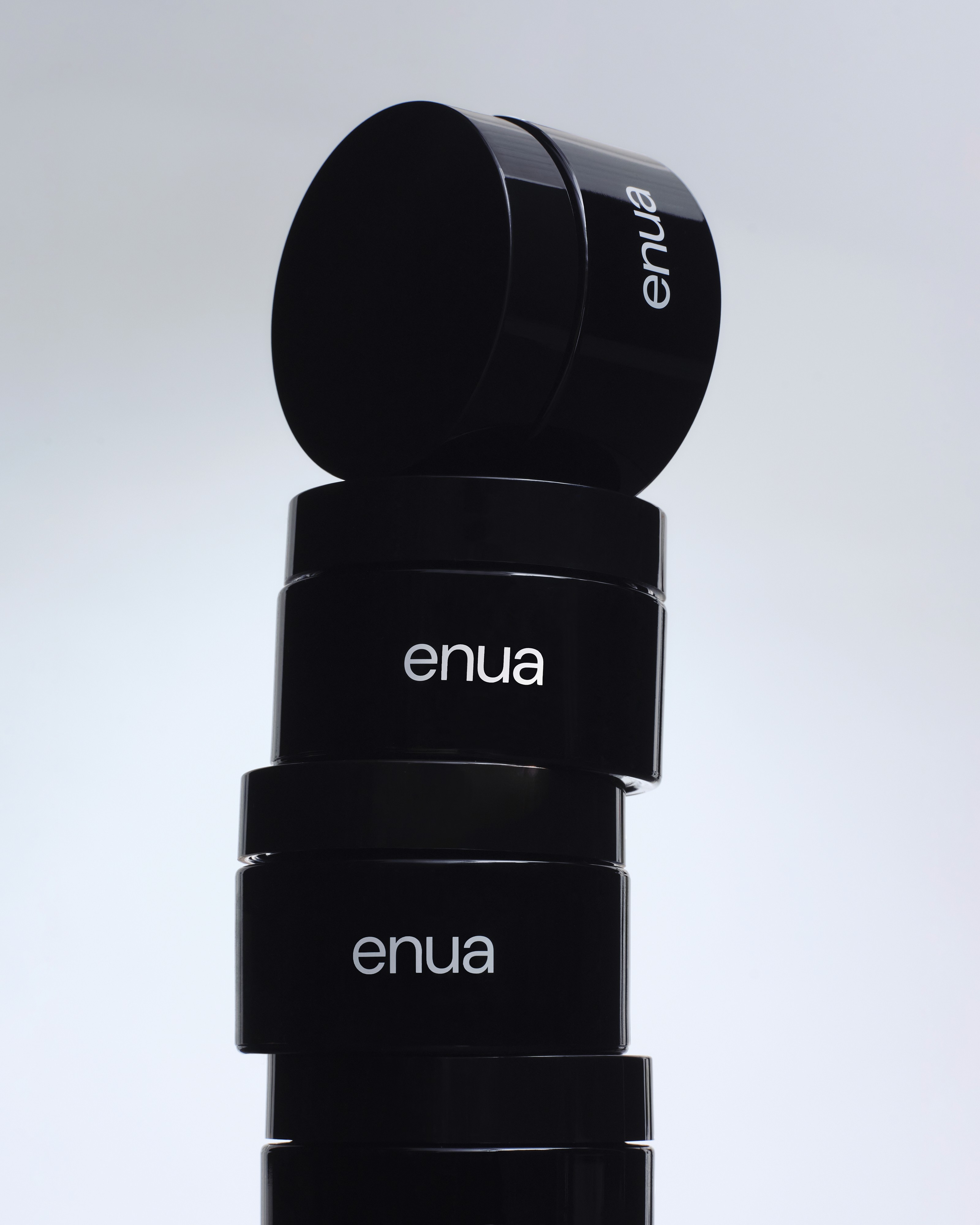 Ein Turm aus vier schwarzen enua Aufbewahrungsgläsern, die für medizinisches Cannabis genutzt werden.