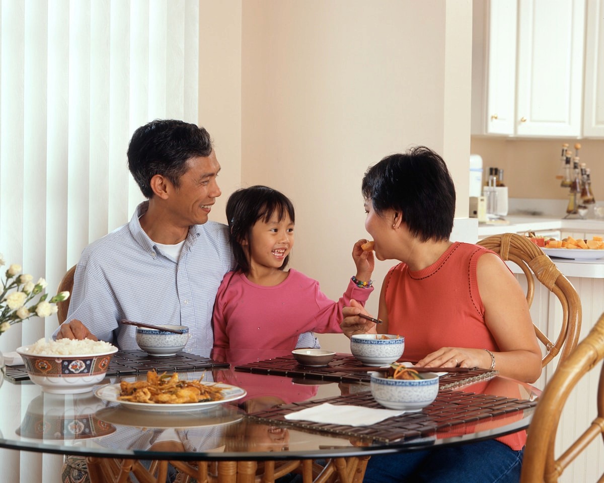 A family eating a meal together at the table, illustrating a calm, low-pressure mealtime environment